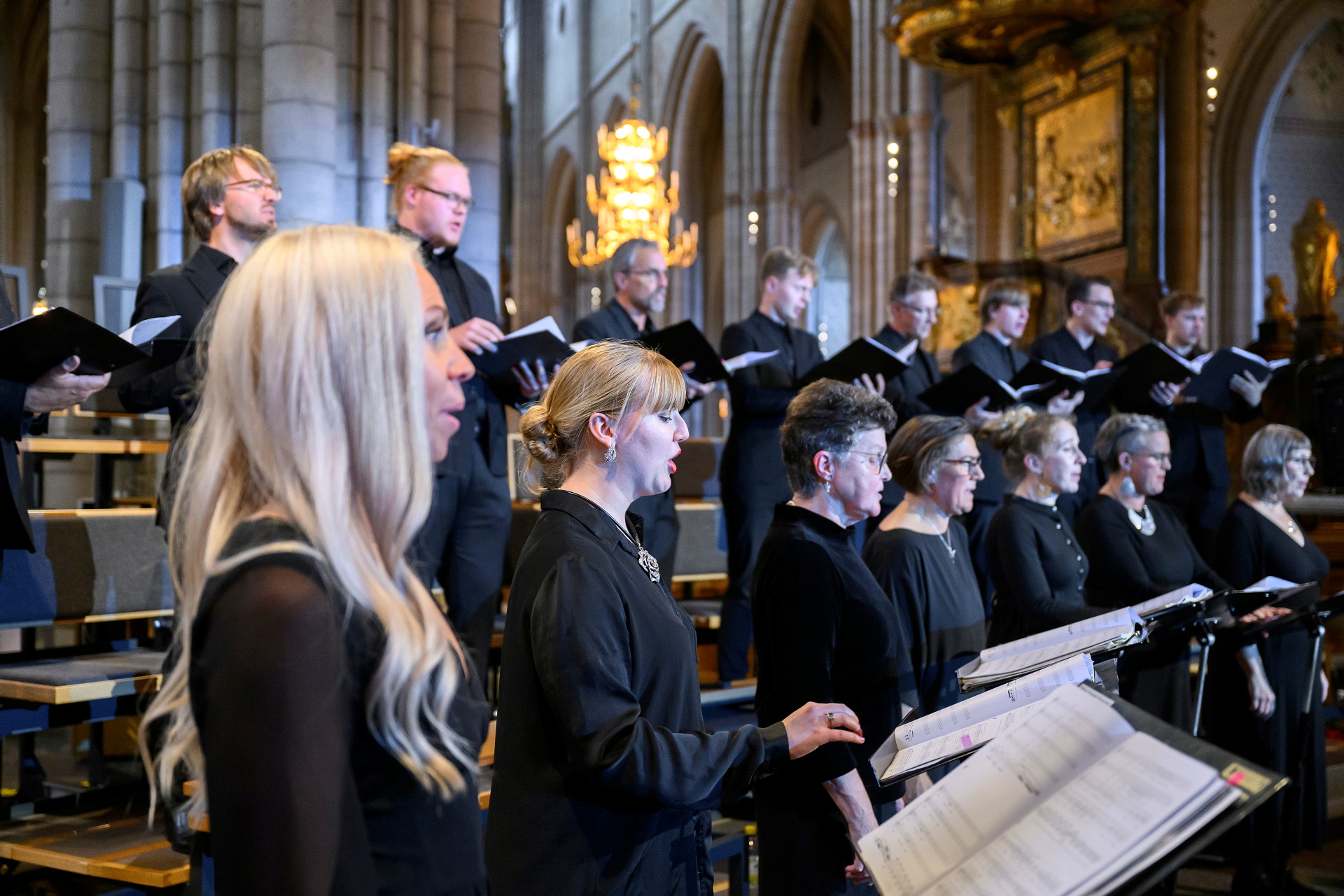 Människor som står i en kyrka och sjunger