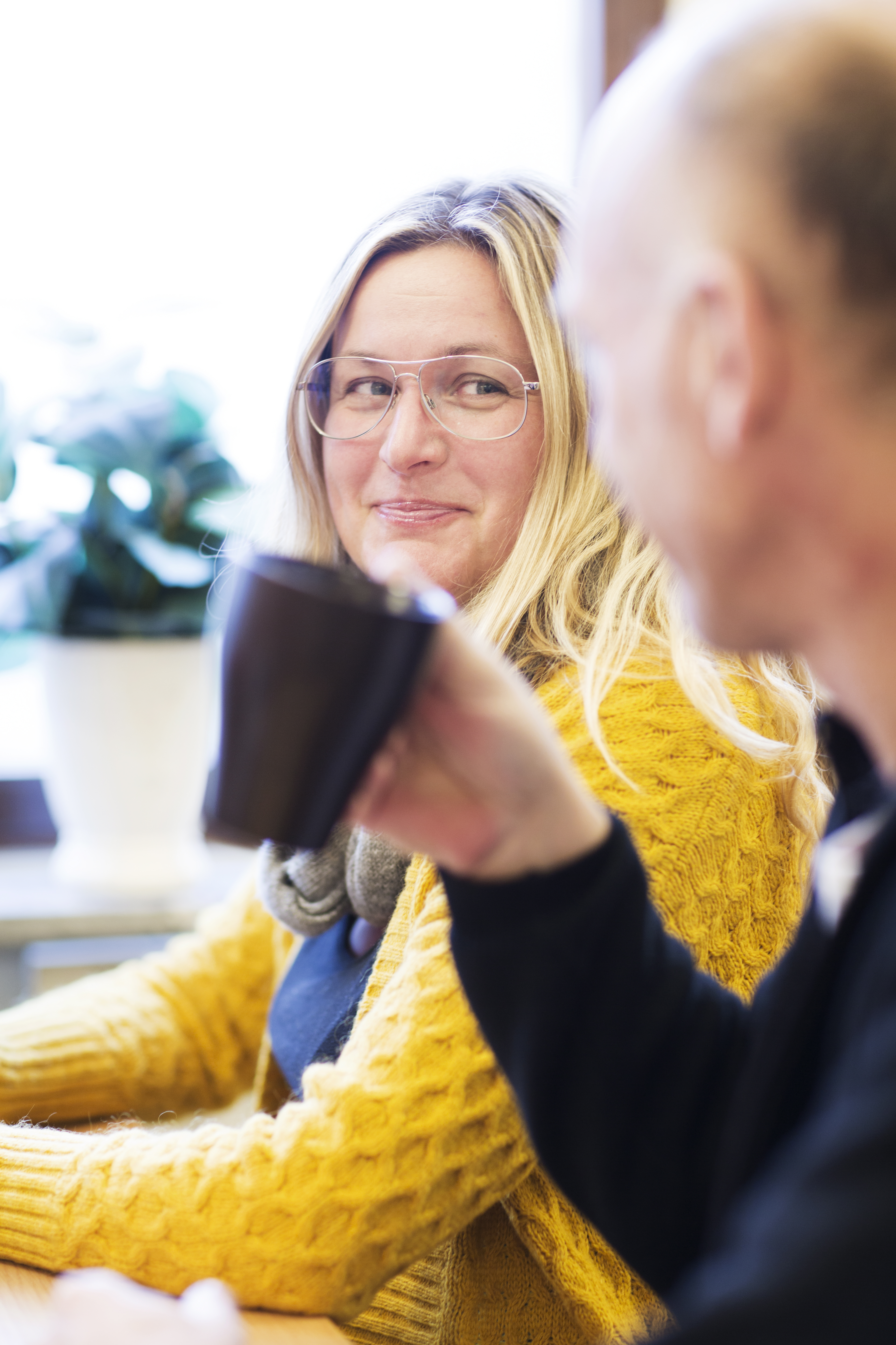 Kvinna dricker kaffe och samtalar med man