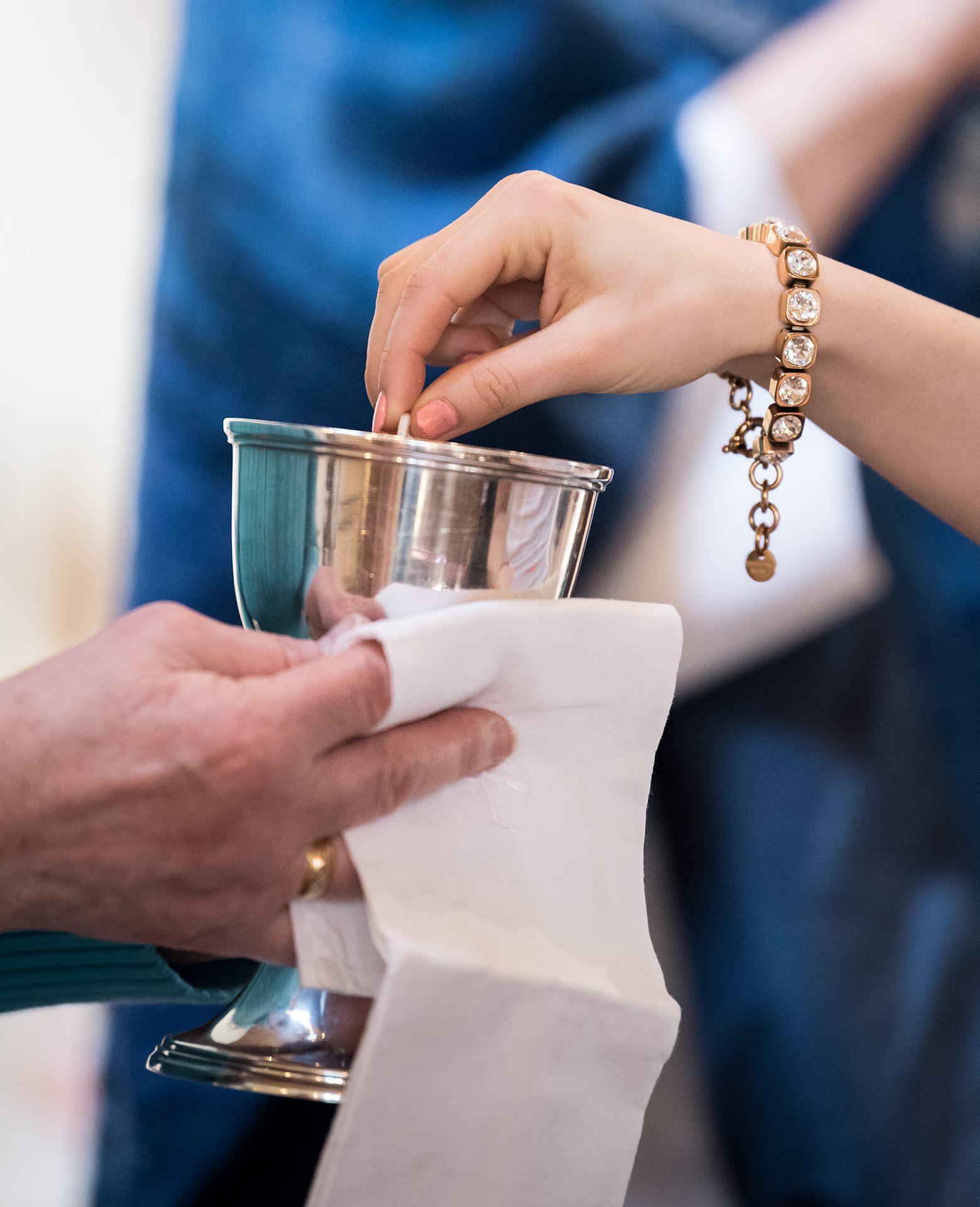 Intinktion, en person doppar ett oblat i en nattvardskalk.