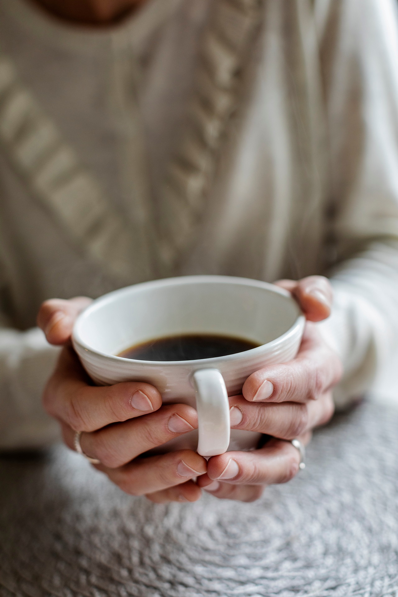 Händer som håller i en kaffekopp