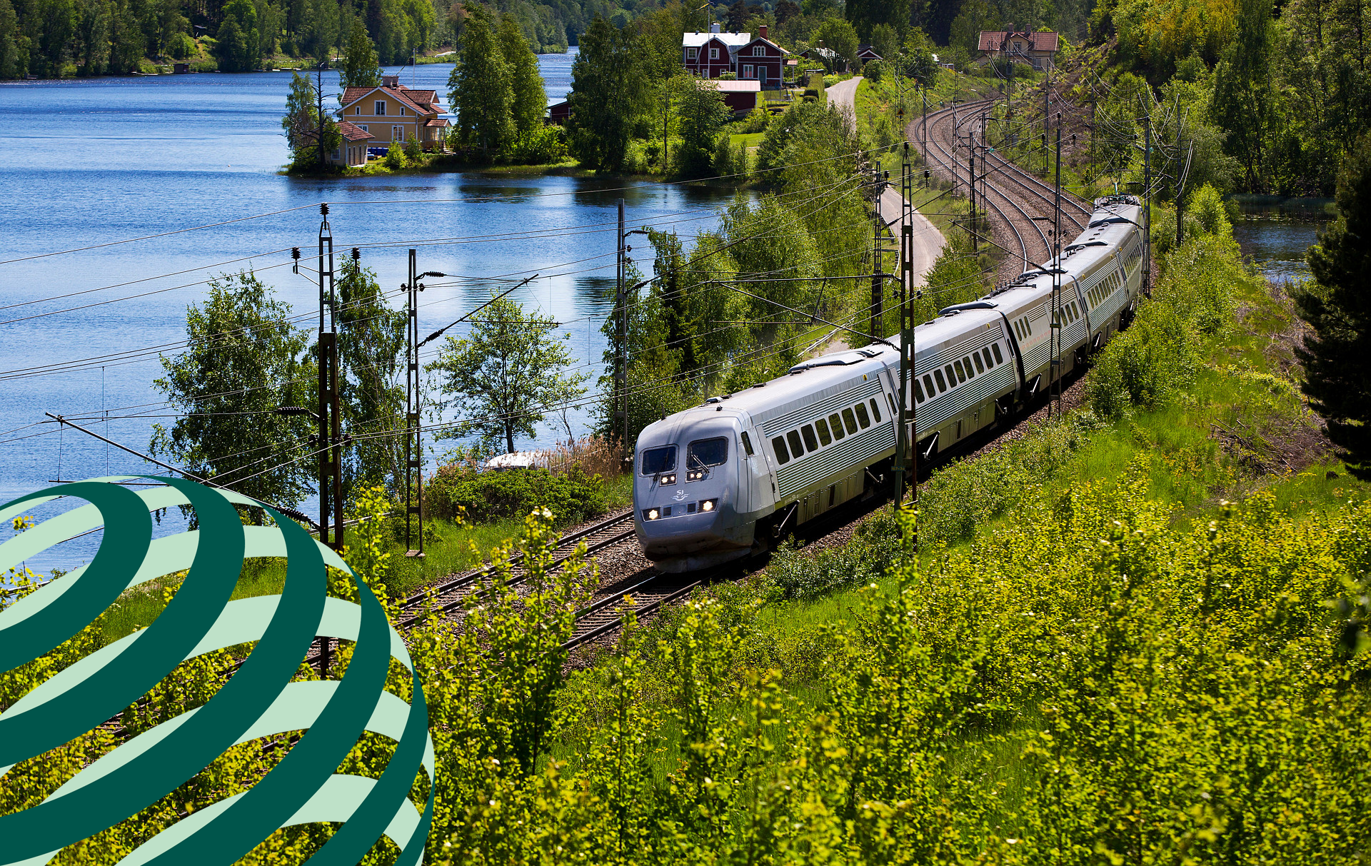 ett tåg som reser genom landksap med sjö och träd omkring