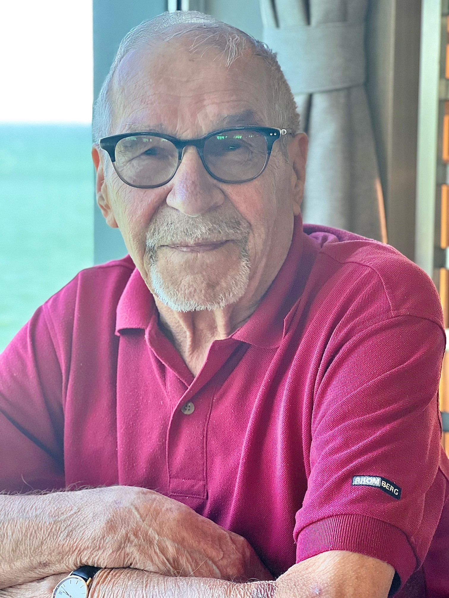 En man i röd piké och glasögon.