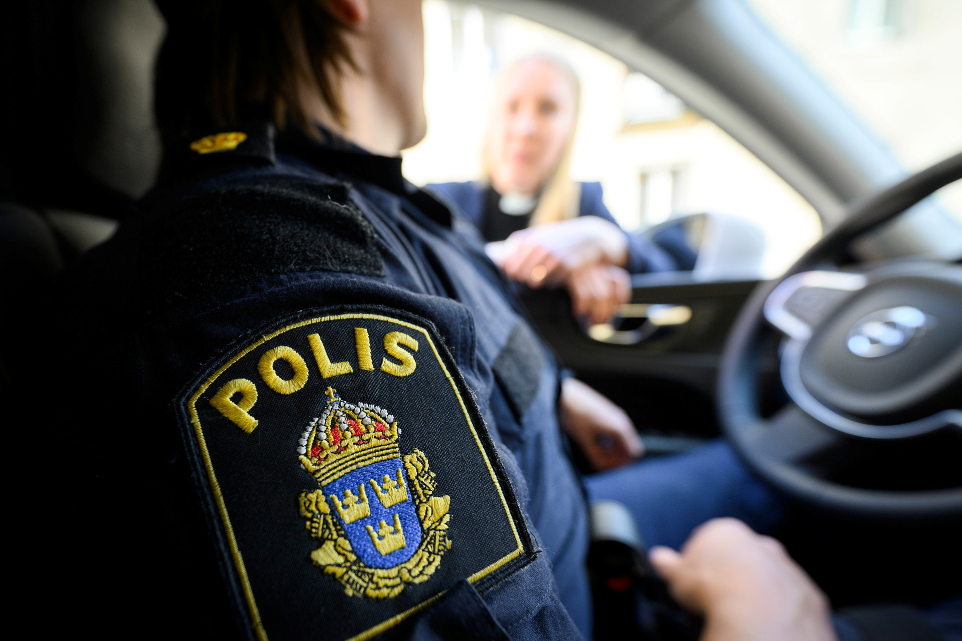 Polis i bil i samtal med präst
