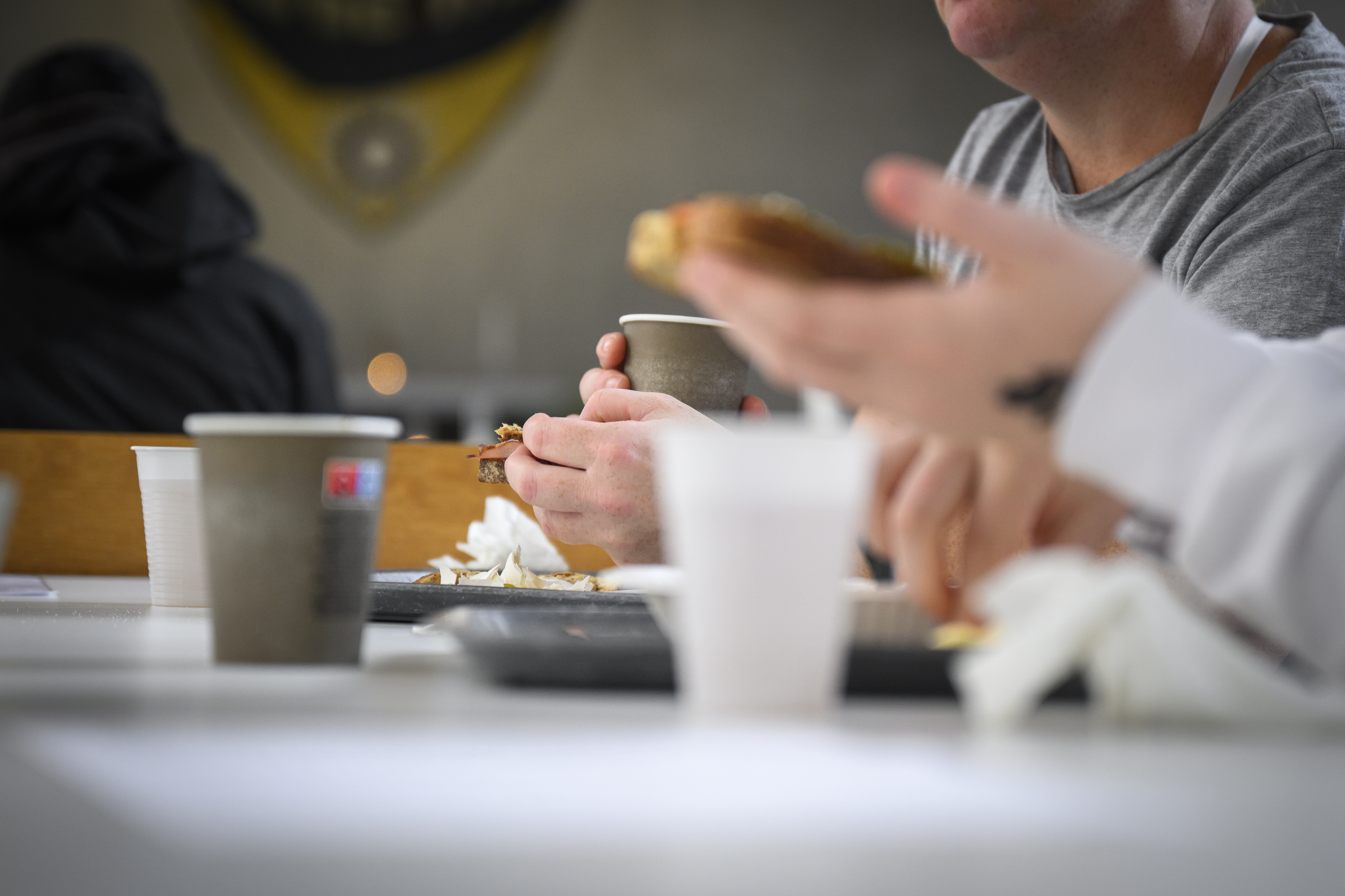 Två människor vars ansikten man inte ser äter frukost vid ett bord