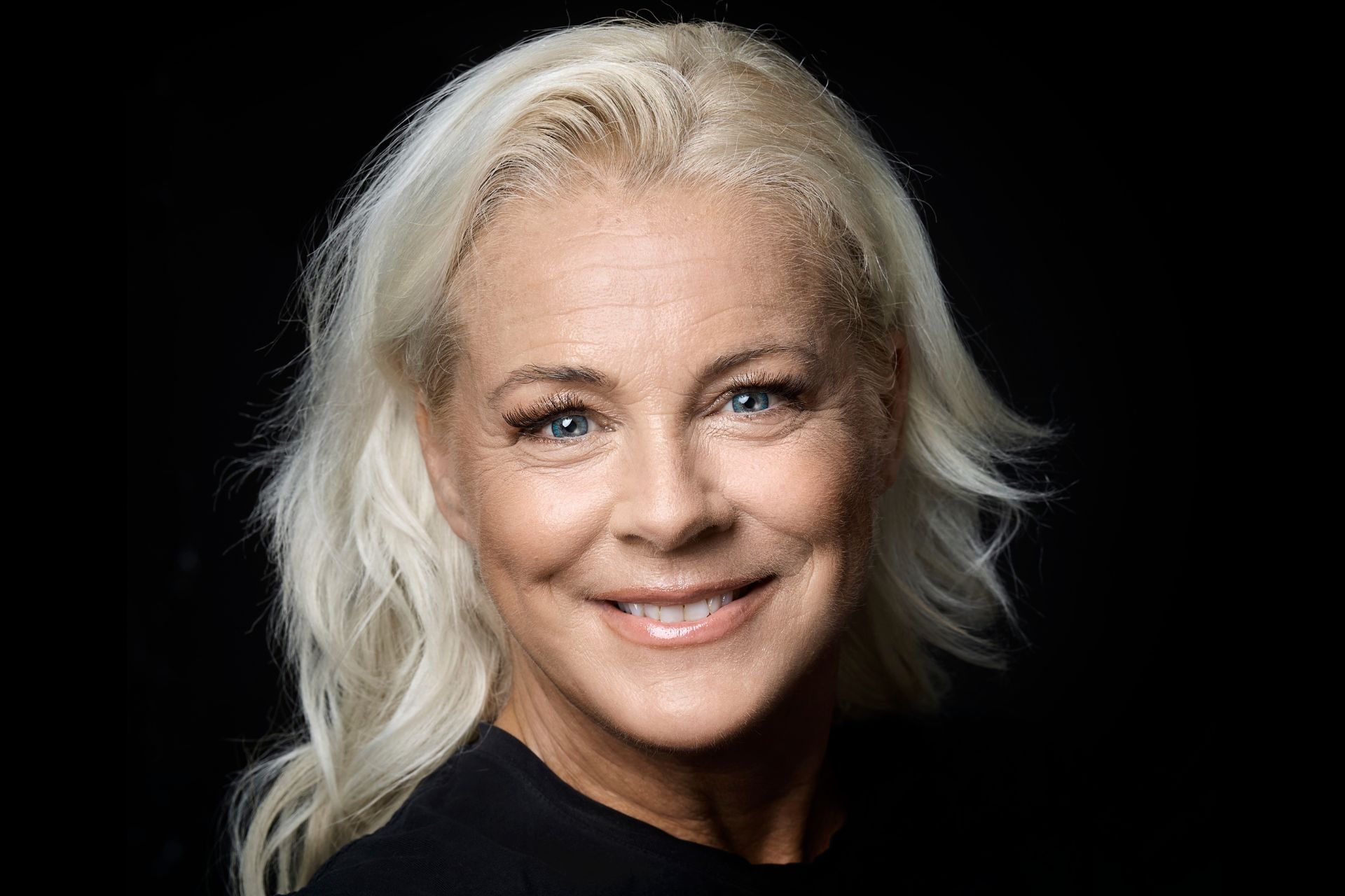 Porträttbild av Malena Ernman mot svart bakgrund.