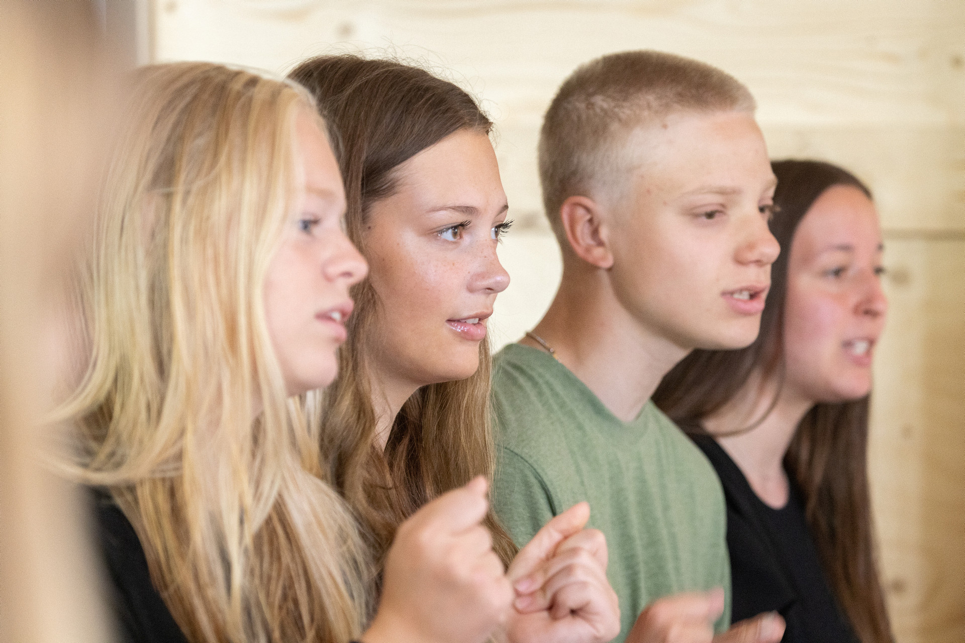 Tre tonårsflickor och en pojke som sjunger/pratar. 