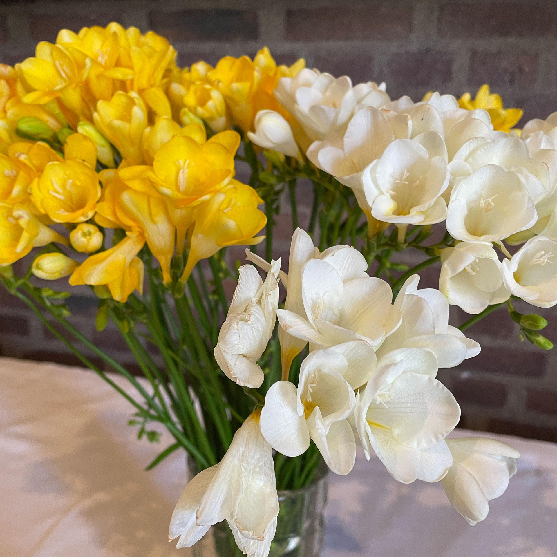 Blommor i vitt och gult på ett altare.