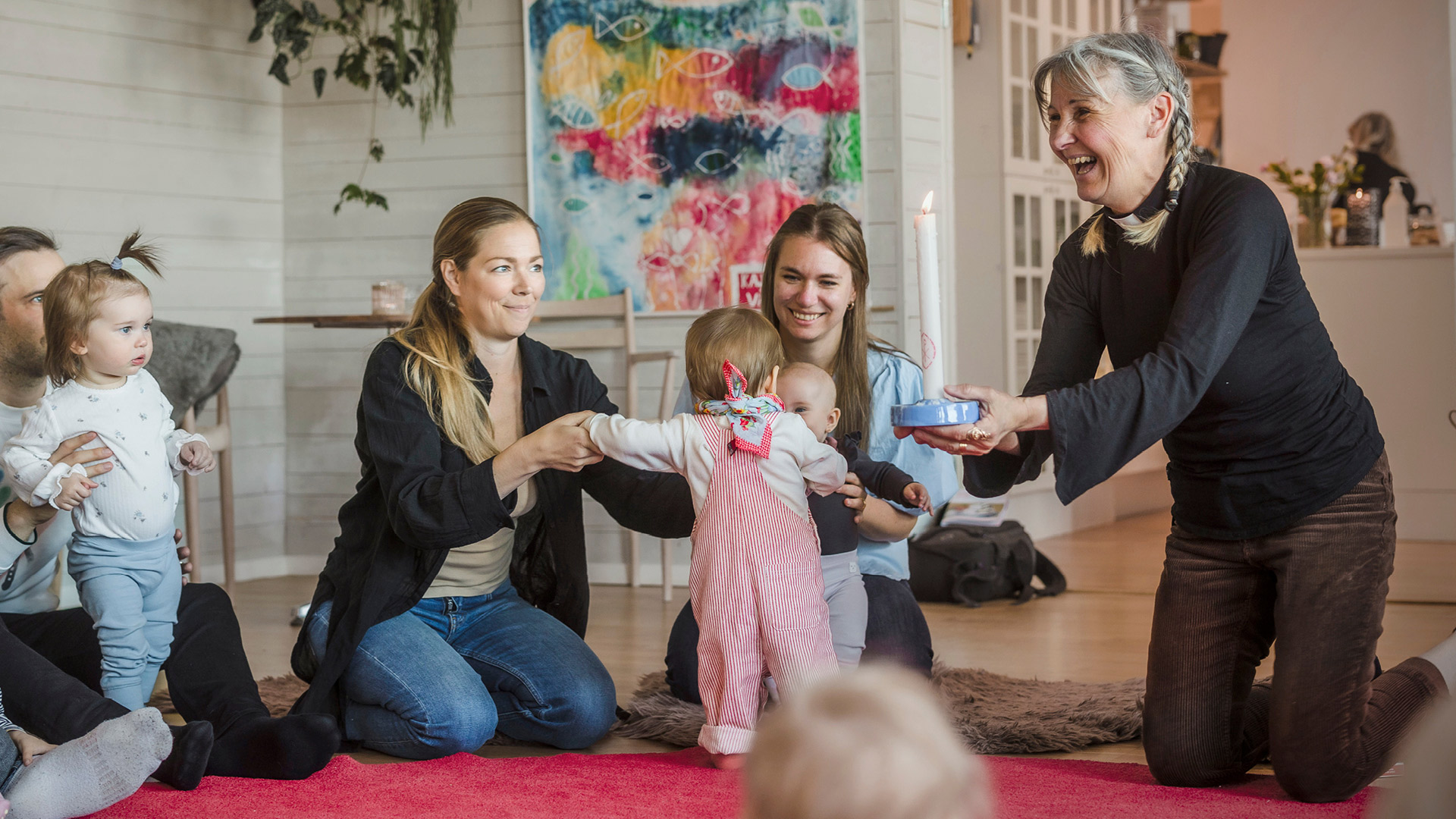 Föräldrar med barn på rytmiksamling på Kvarterskyrkan på kajen.