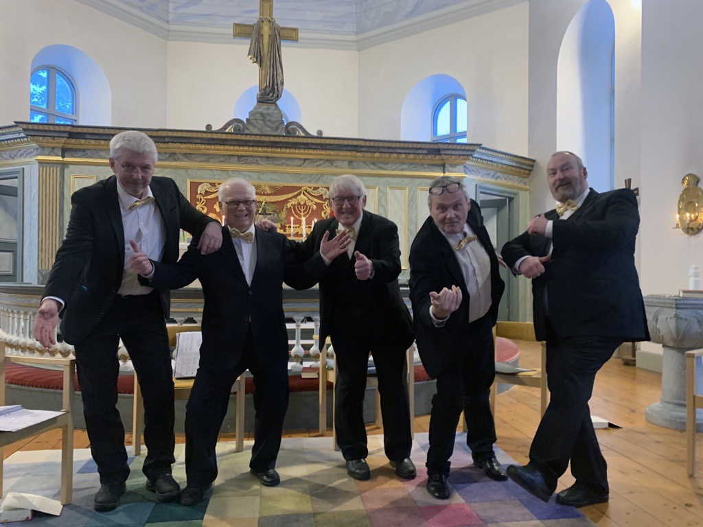 Fem välklädda äldre gentlemän tillika körsångare i Junsele kyrka.