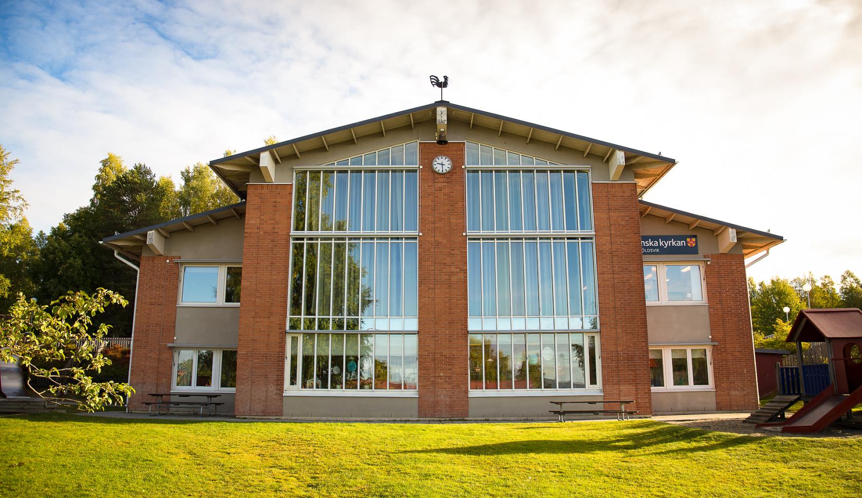 En stor tegelbyggnad med stora fönster. 