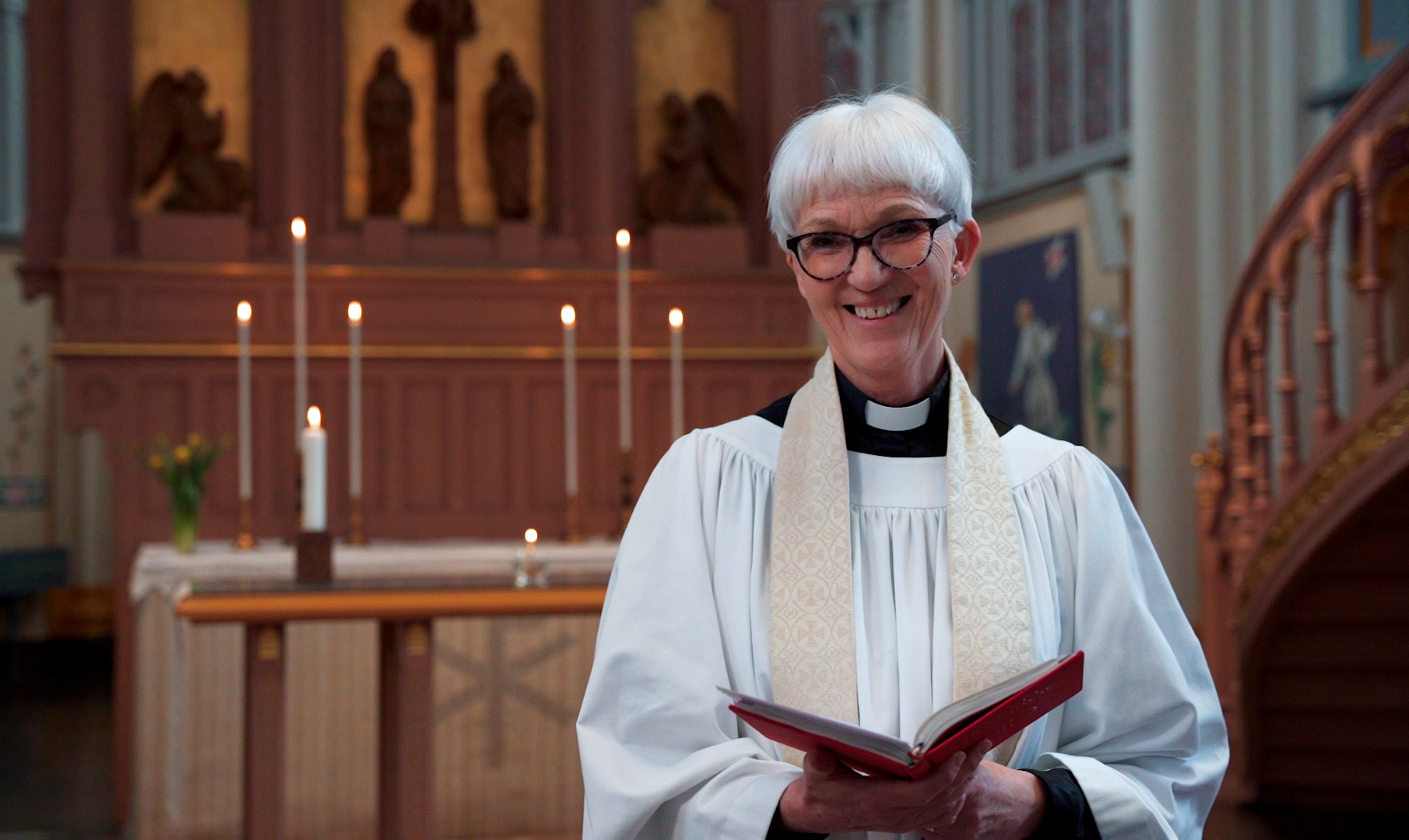 En kvinna som står framför ett altare i en kyrka