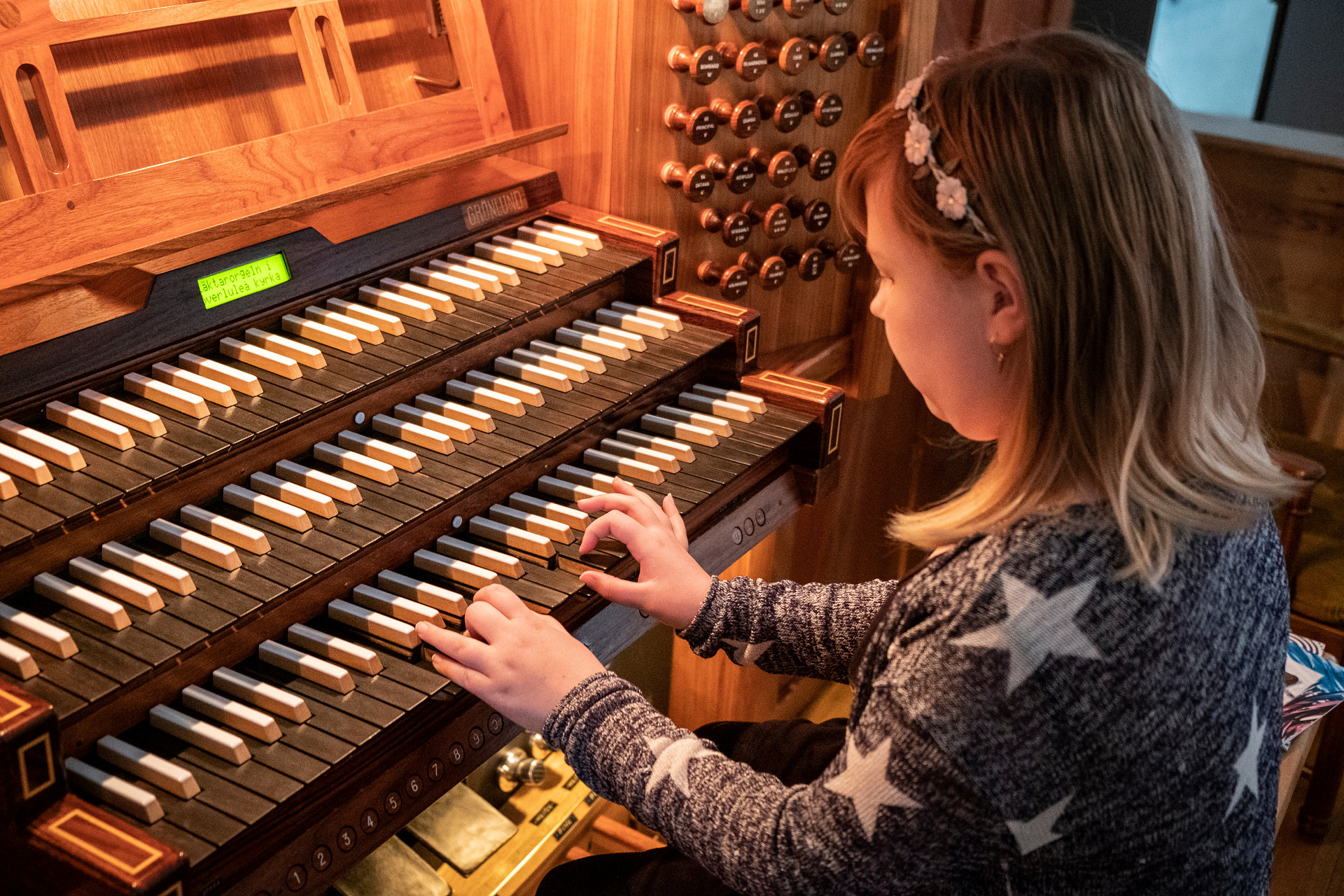 En flicka spelar kyrkorgel.