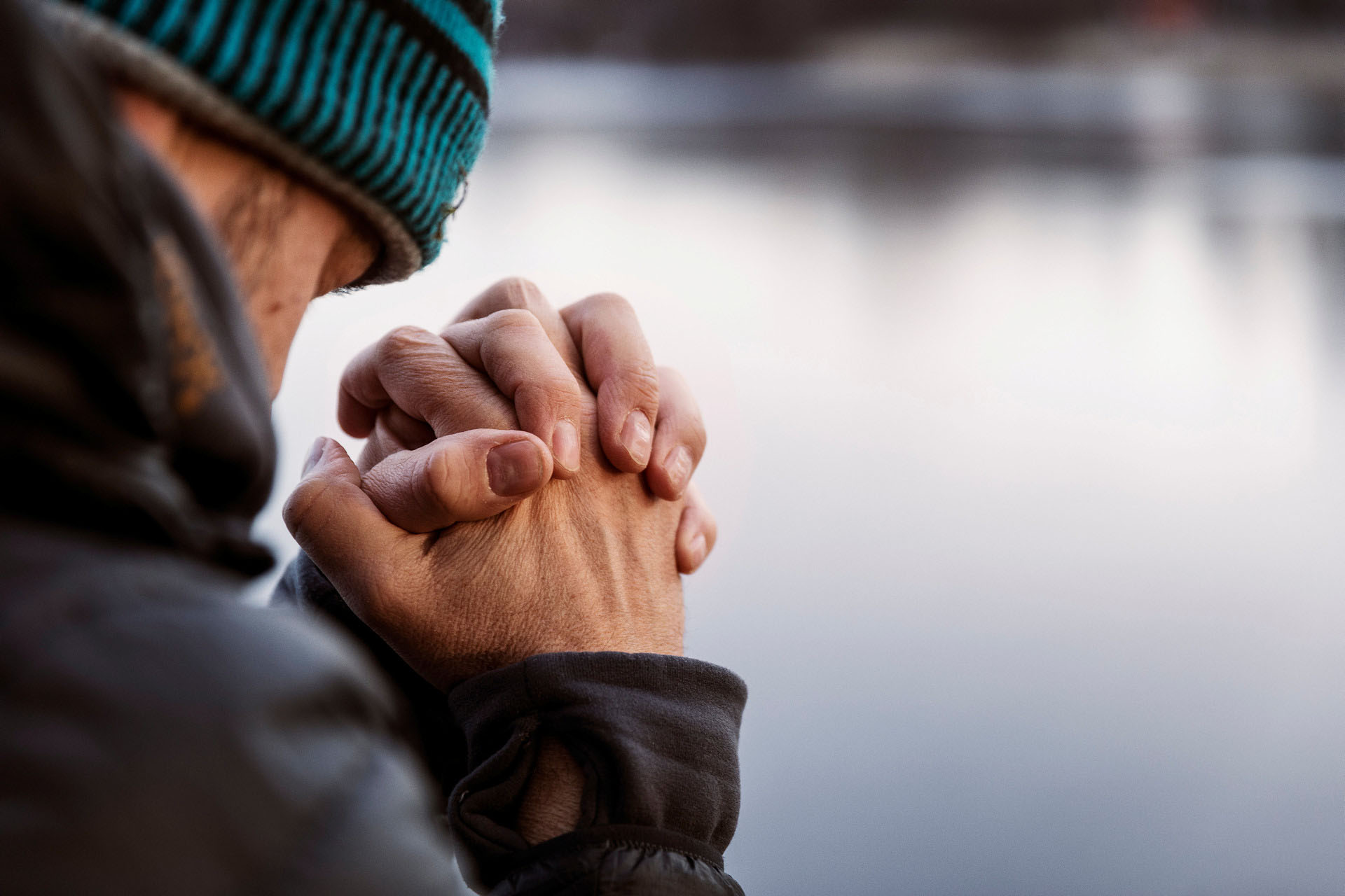 En man som ber, bilden tagen snett bakifrån.