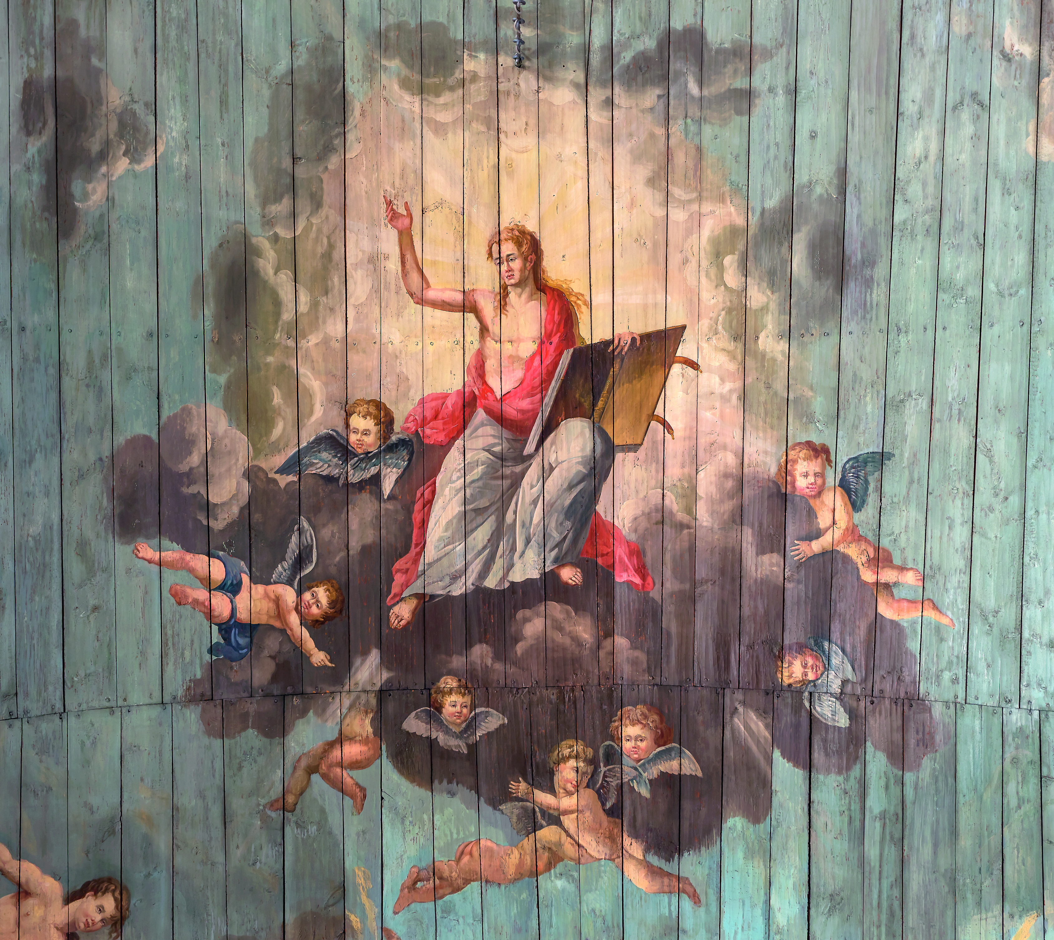 Ett kyrktak i trä med en målad kristusbild bland moln