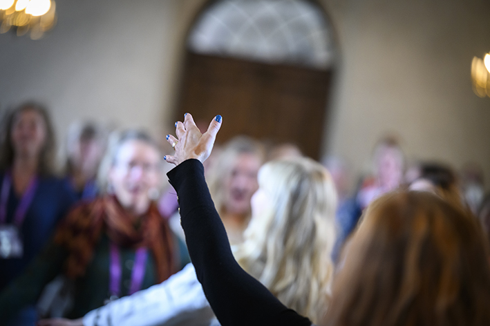 En arm som dirigerar en kör.