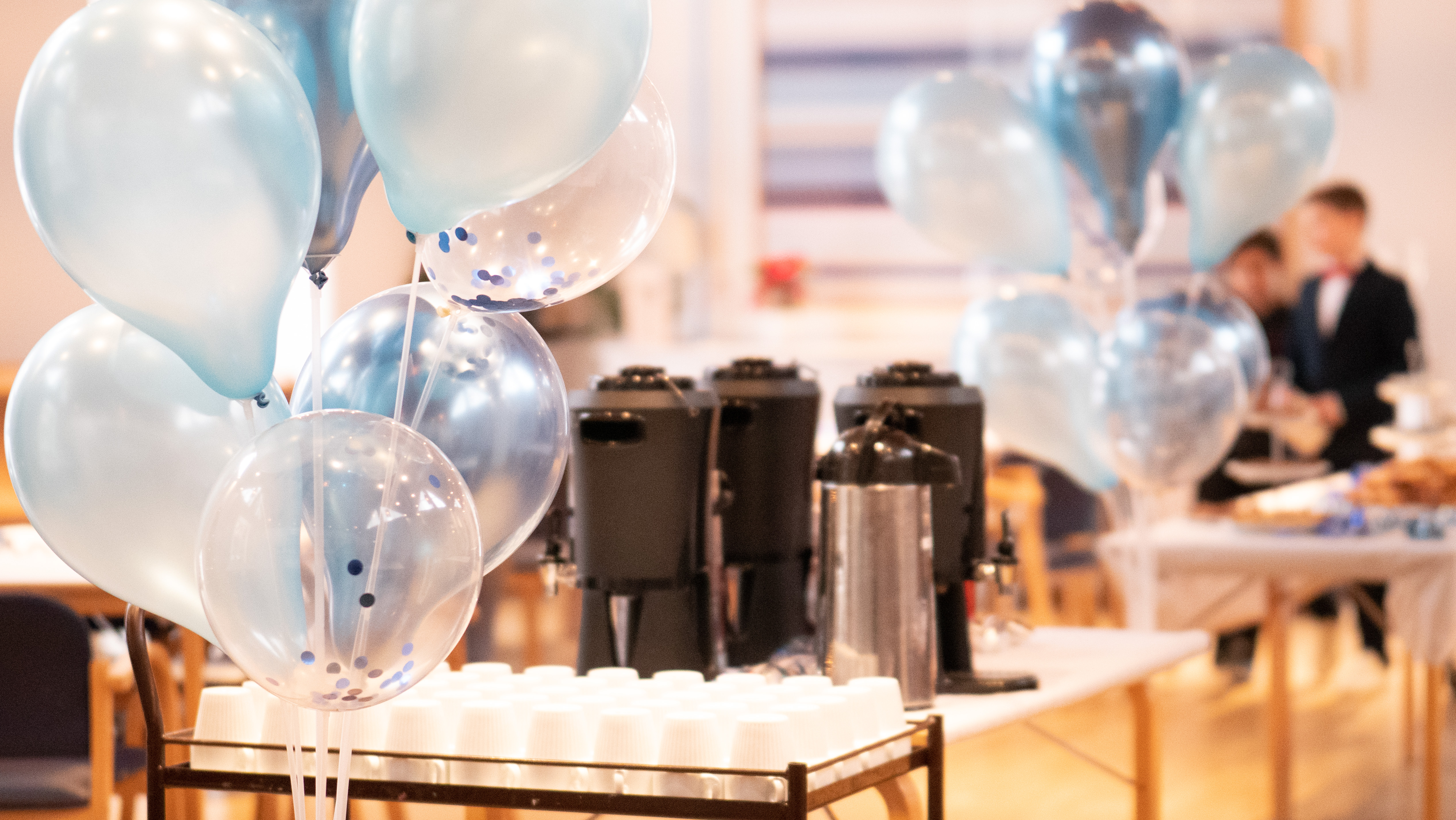 Ballonger och ett långbord uppdukat med kaffe. 