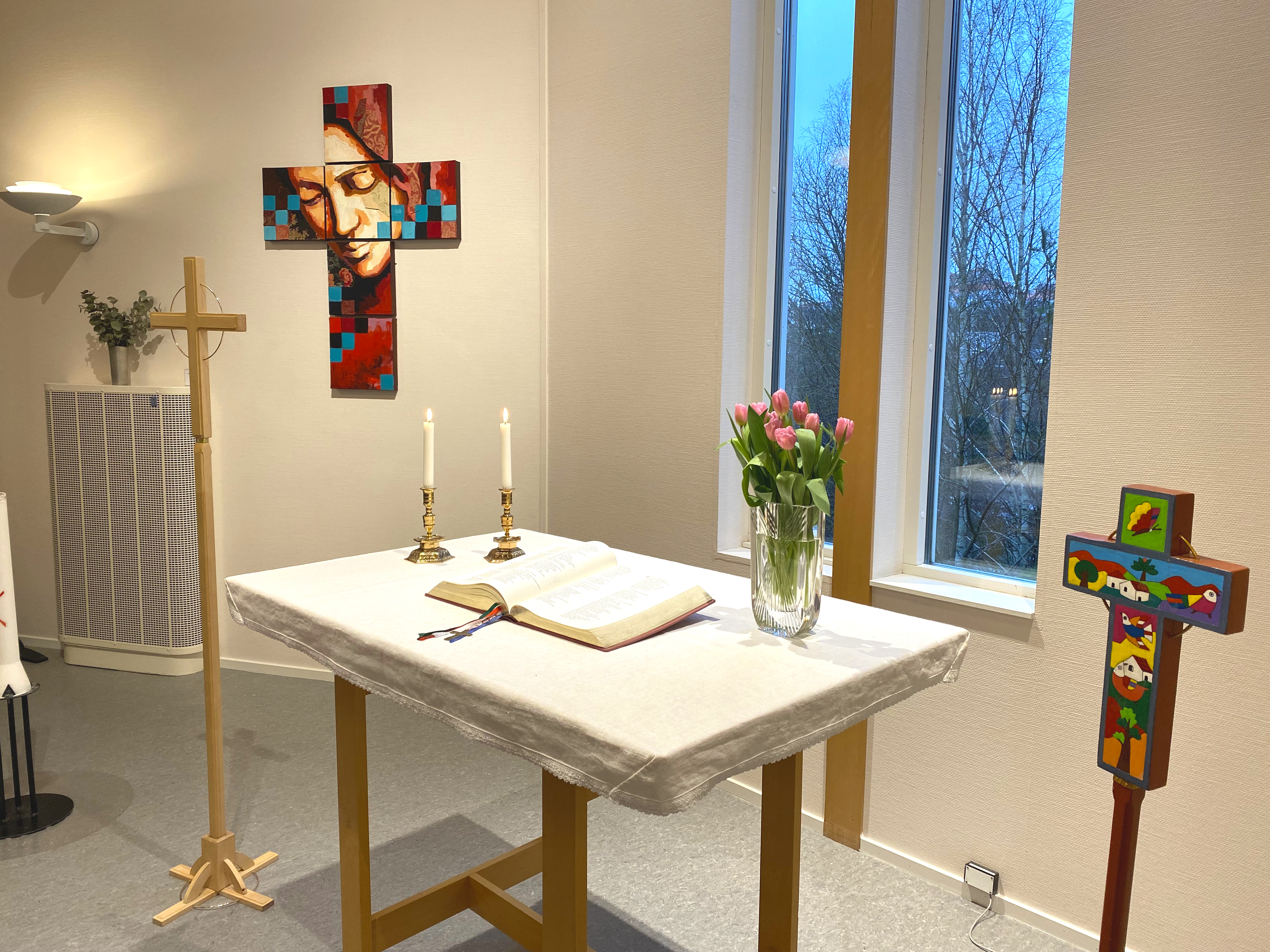 Altare i Forumkyrkan med blommor, ljus och bibel. 