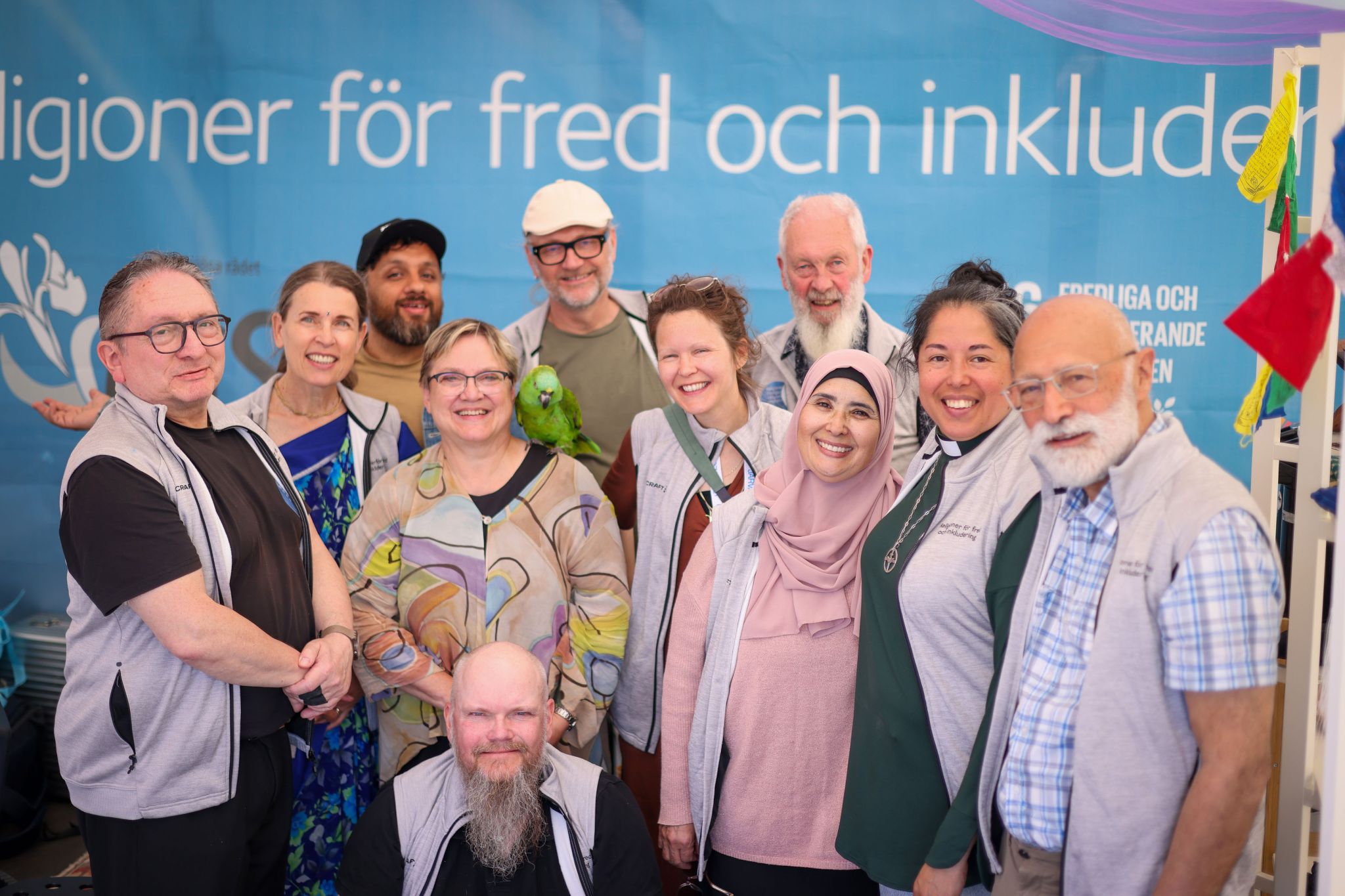 En gruppbild med många glada människor.