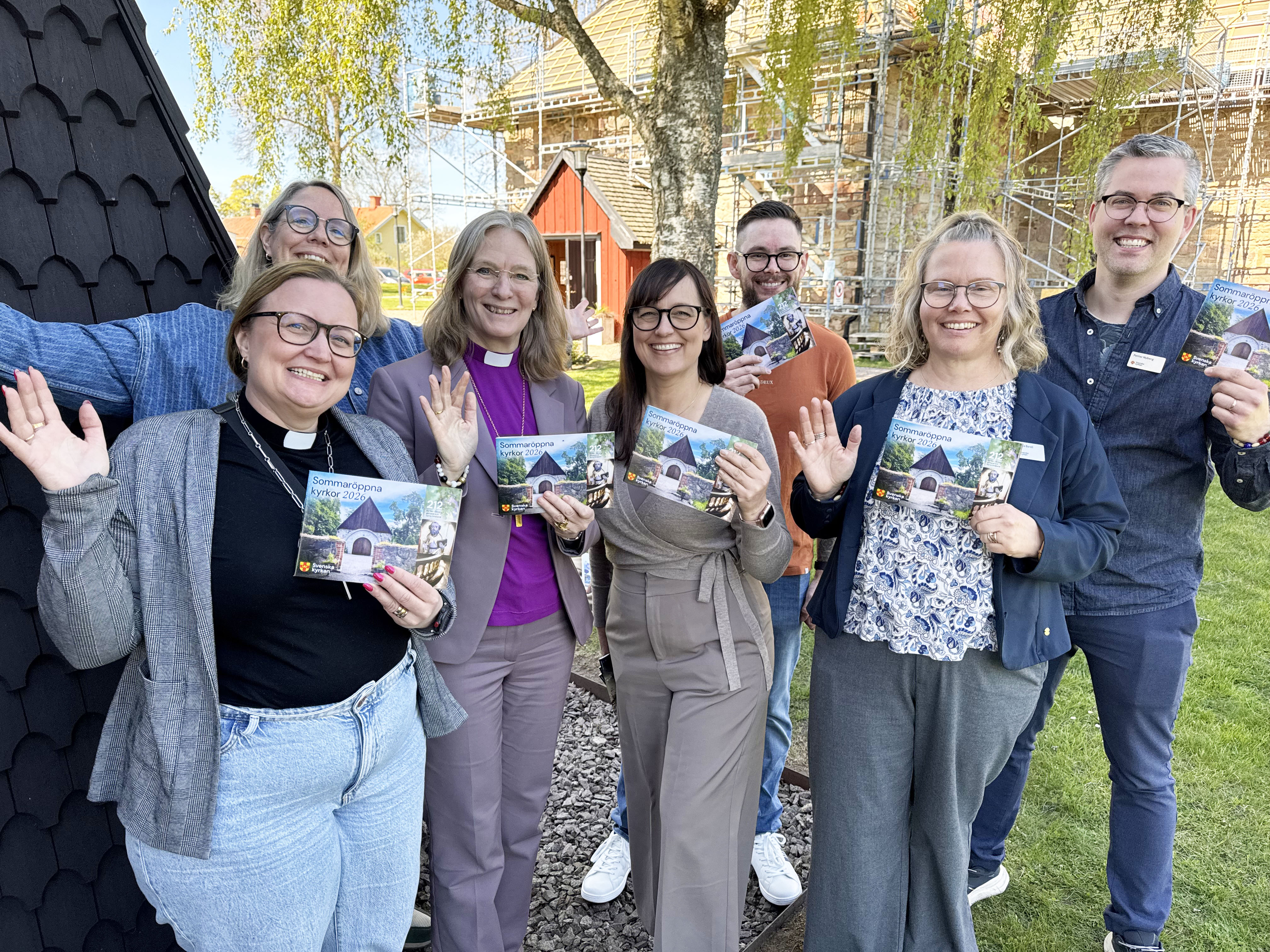 Theresia Österlund, Cecilia Öberg, biskop Marika, Pernilla Stridh, Mikael Lindholm, Anette Borell och Petter Nyberg utanför Veta kyrka i samband med releasefest för Sommaröppna kyrkor 2026.