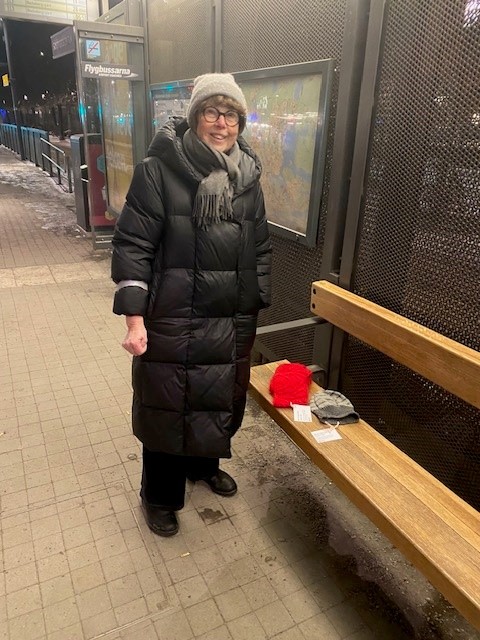 Maj-Stina lägger ut handgjorda alster på en hållplats