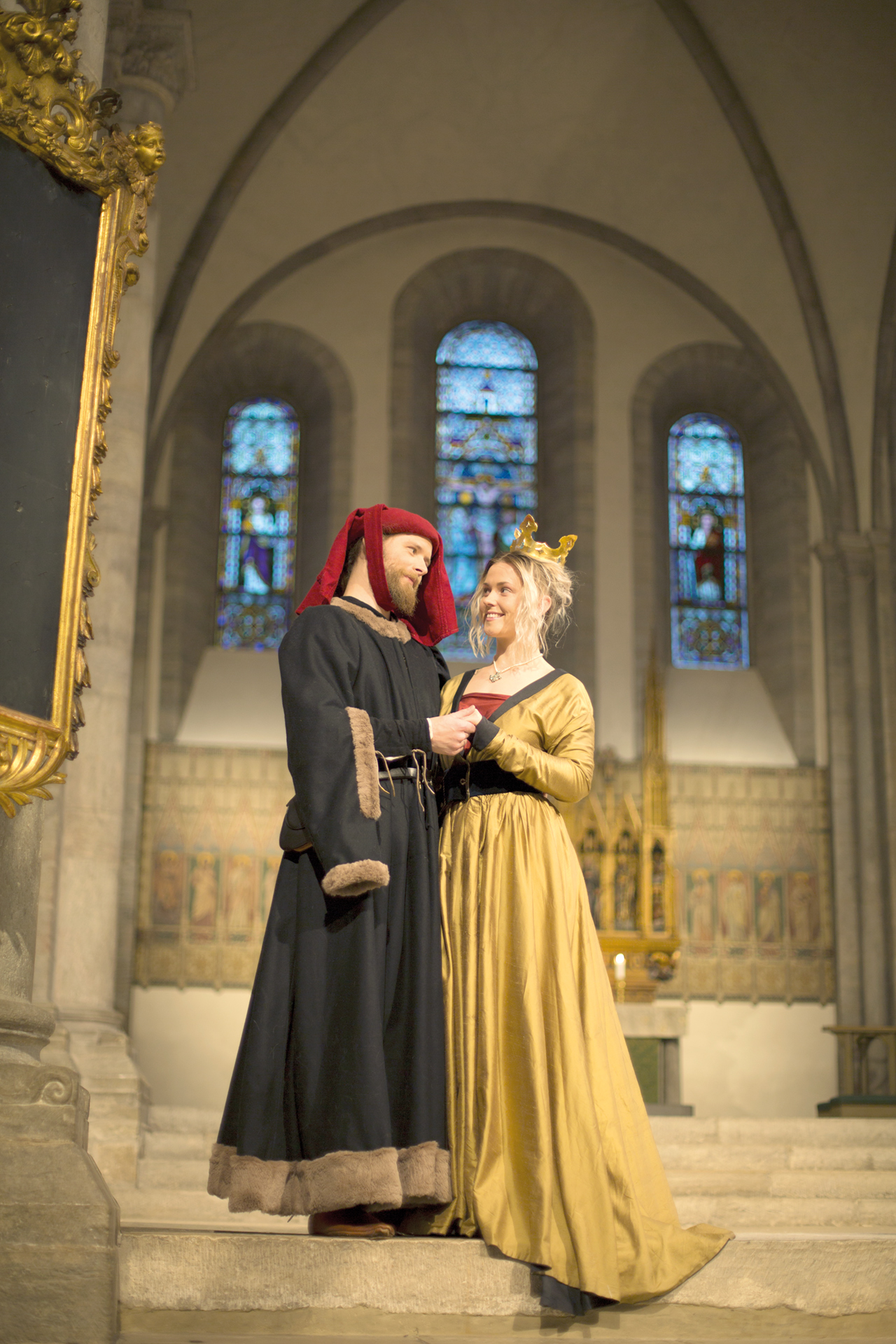 Ett medeltida vigselpar tittar ömt på varandra i domkyrkan.