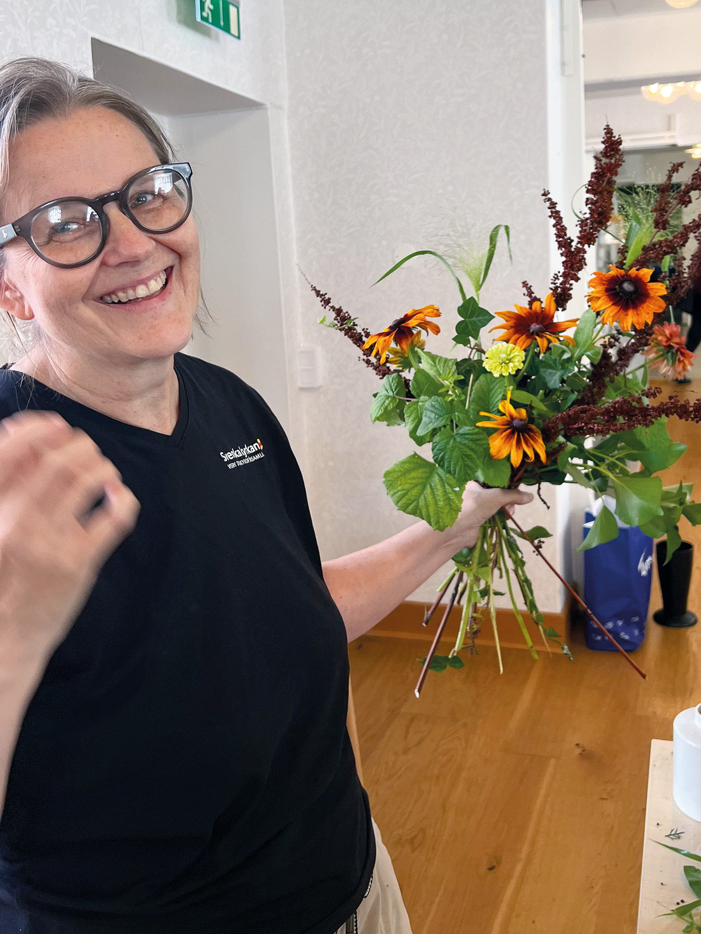 leende kvinna med blomsterbukett i handen