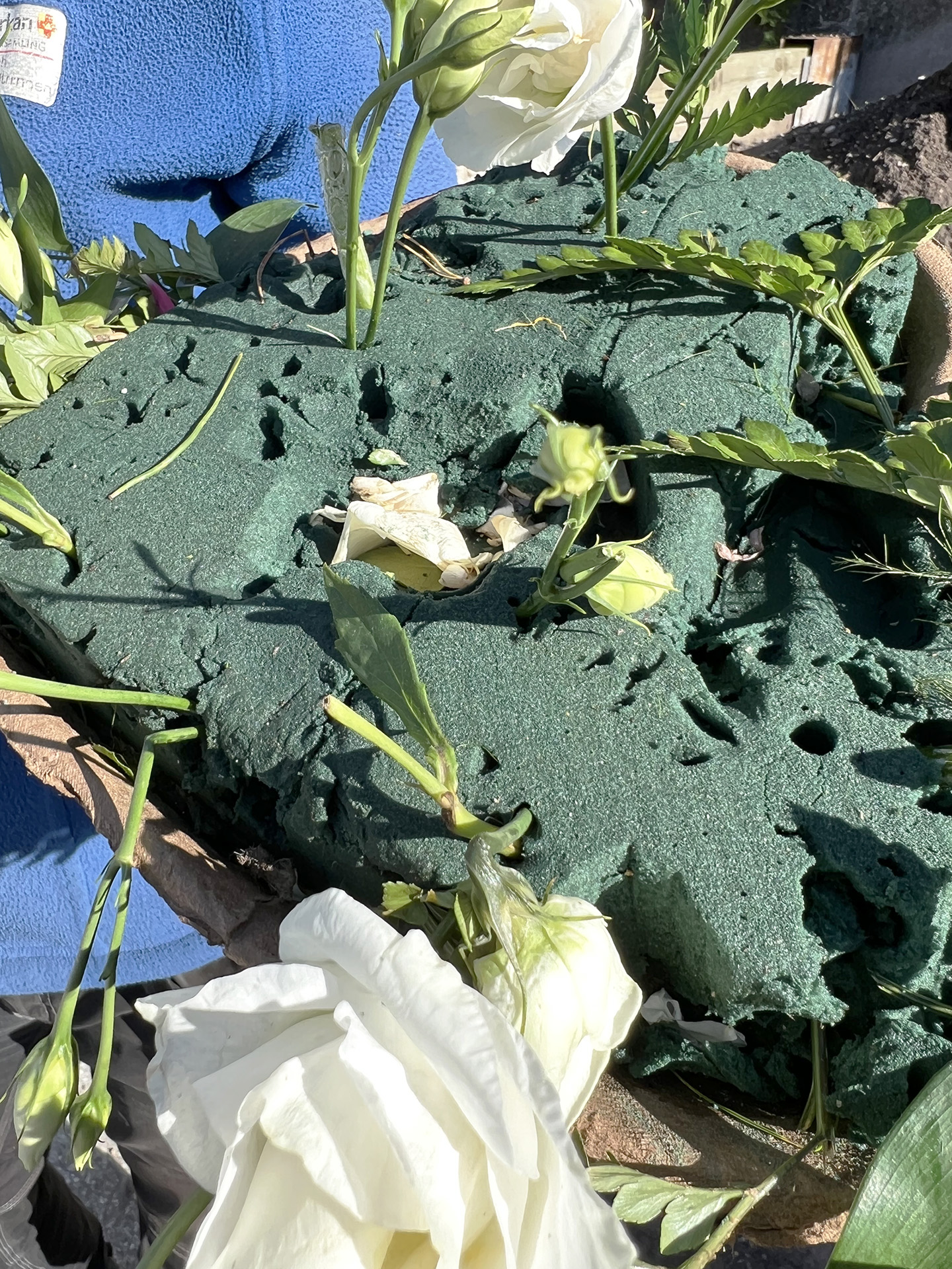 vissna blommor i grön plastklump