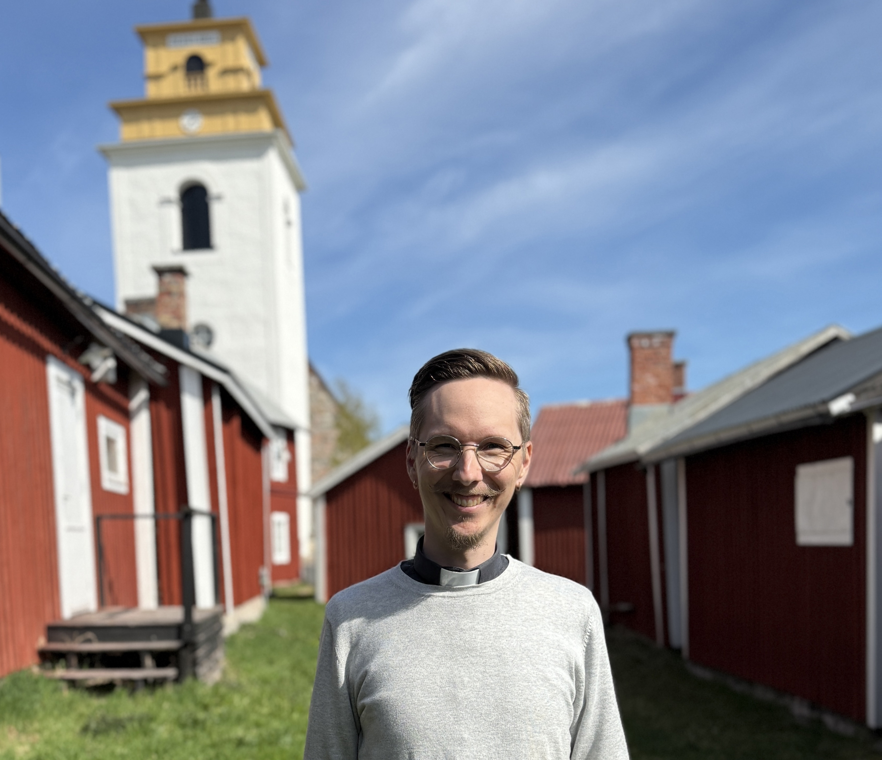 Bilden visar nye kyrkoherden Petter Edberg stående framför kyrktornet i Gammelstads kyrkstad.s