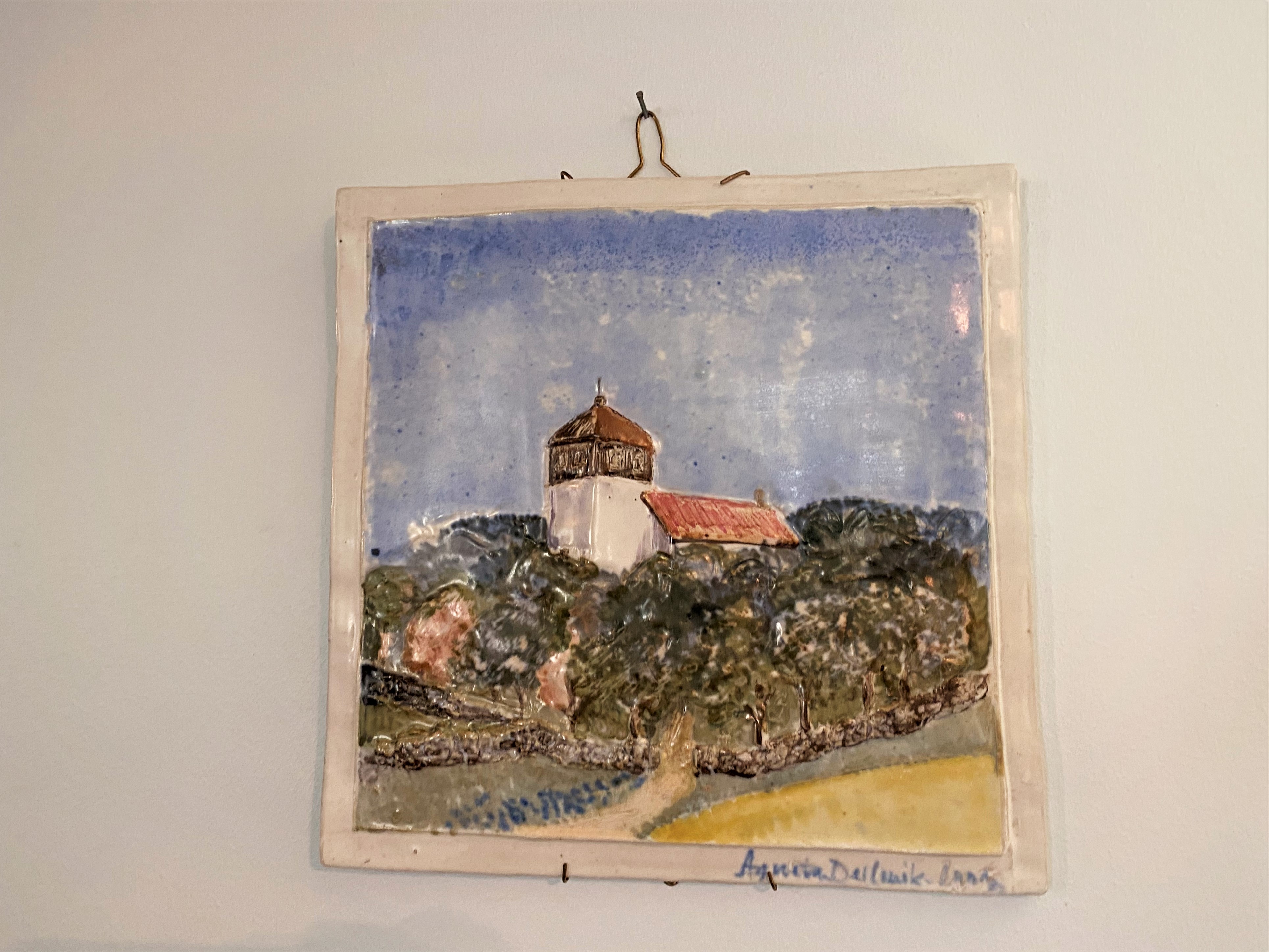 Liten fyrkantig tavla där Morlanda kyrka är målad med blank färg.