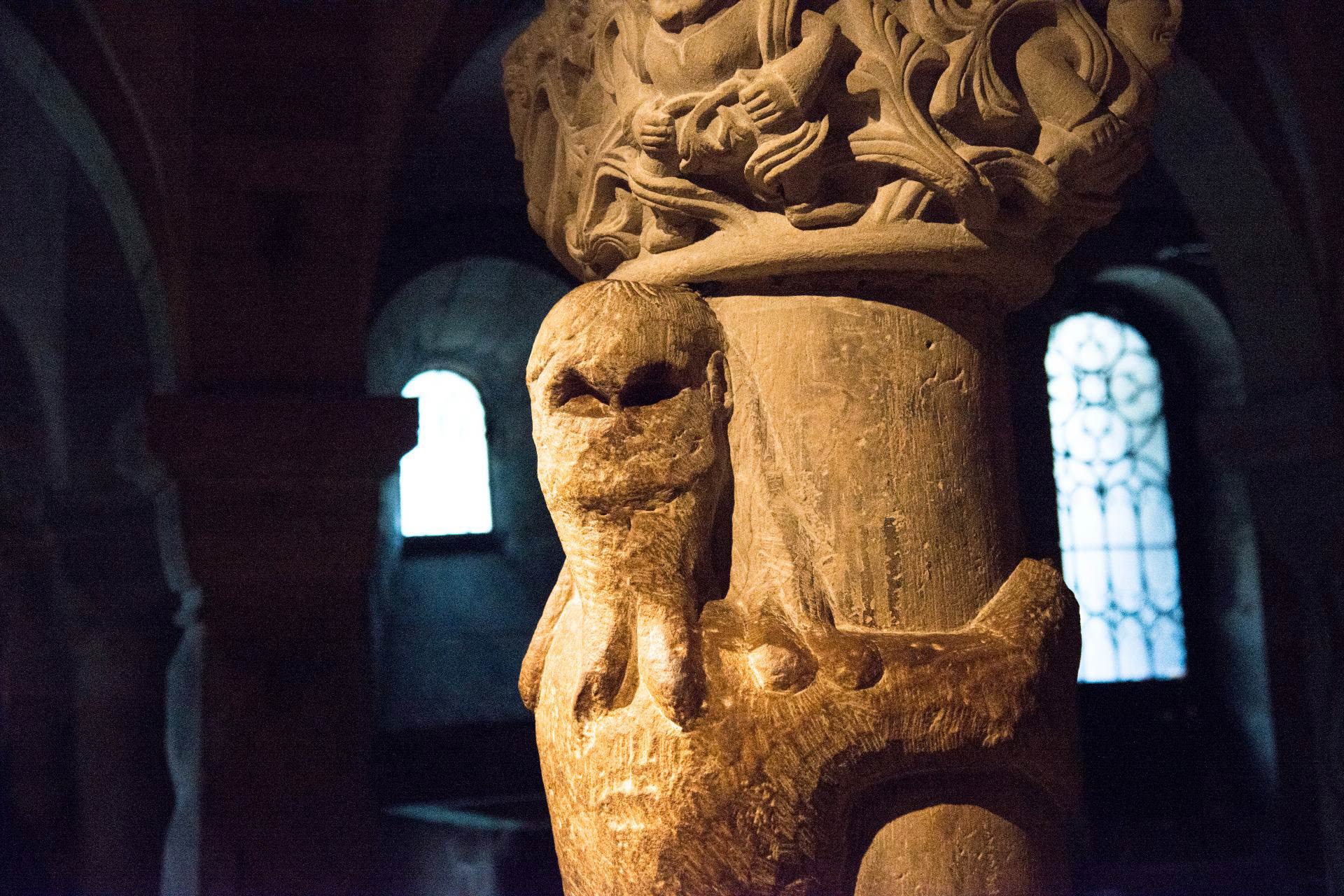 Sandstensskupltur av jätten Finn som kramar en av pelarna i Kryptan.