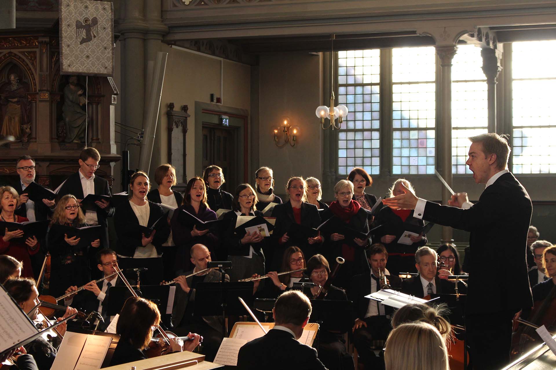 Jakob dirigerar kör och orkester i Oscar Fredriks kyrka.