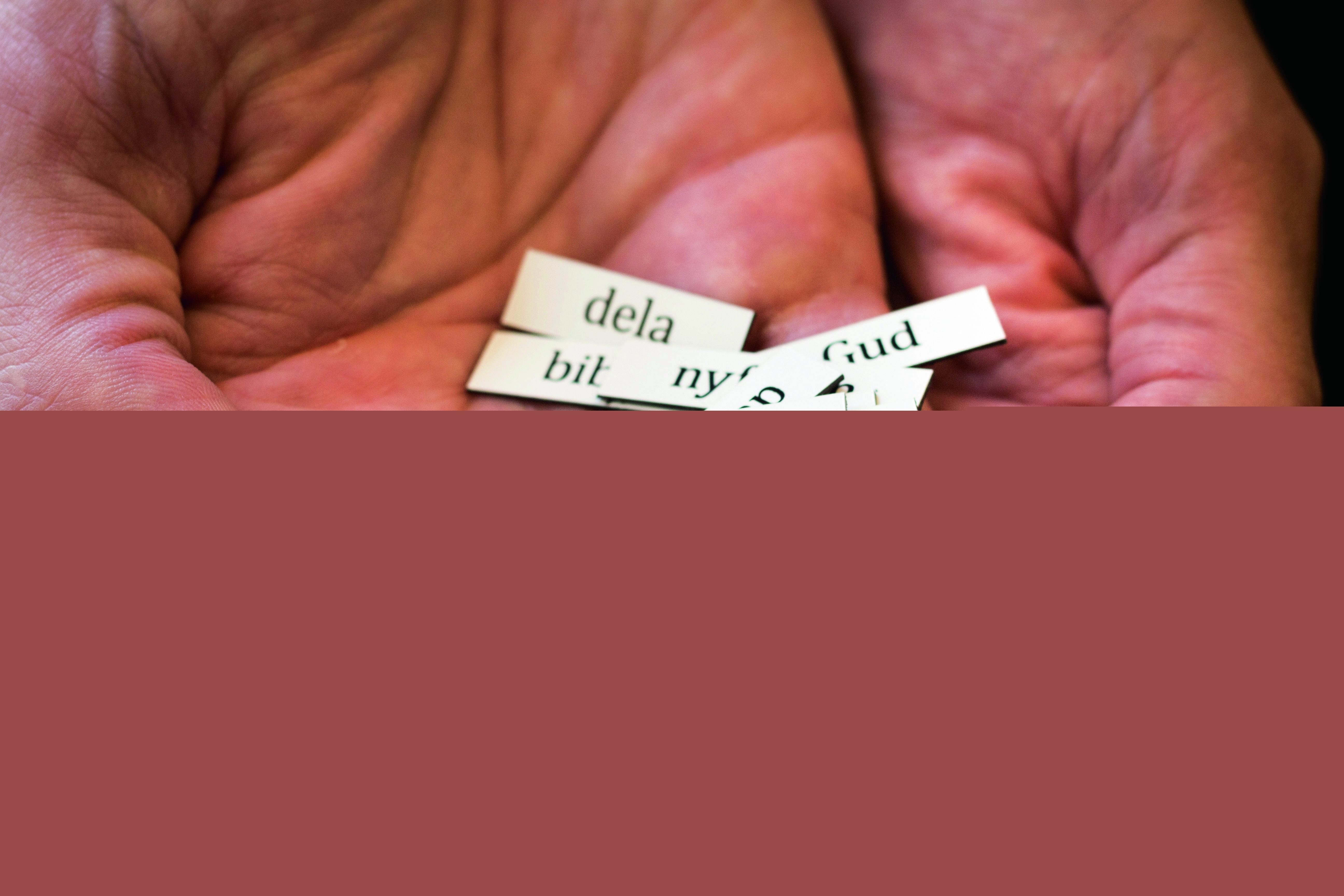 Tbå öppna händer med ordlappar som det står "tro", "tvivel", "livet" på.