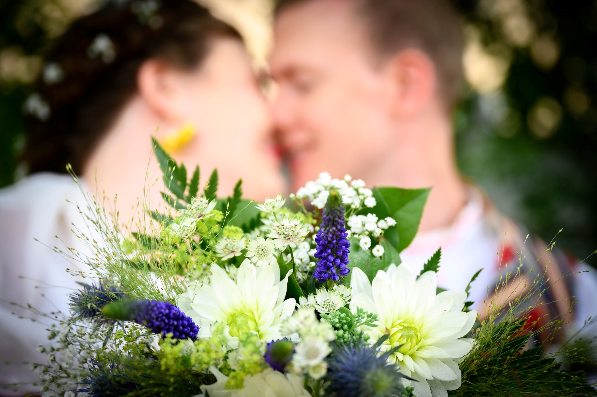 Brudpar med bukett i förgrunden
