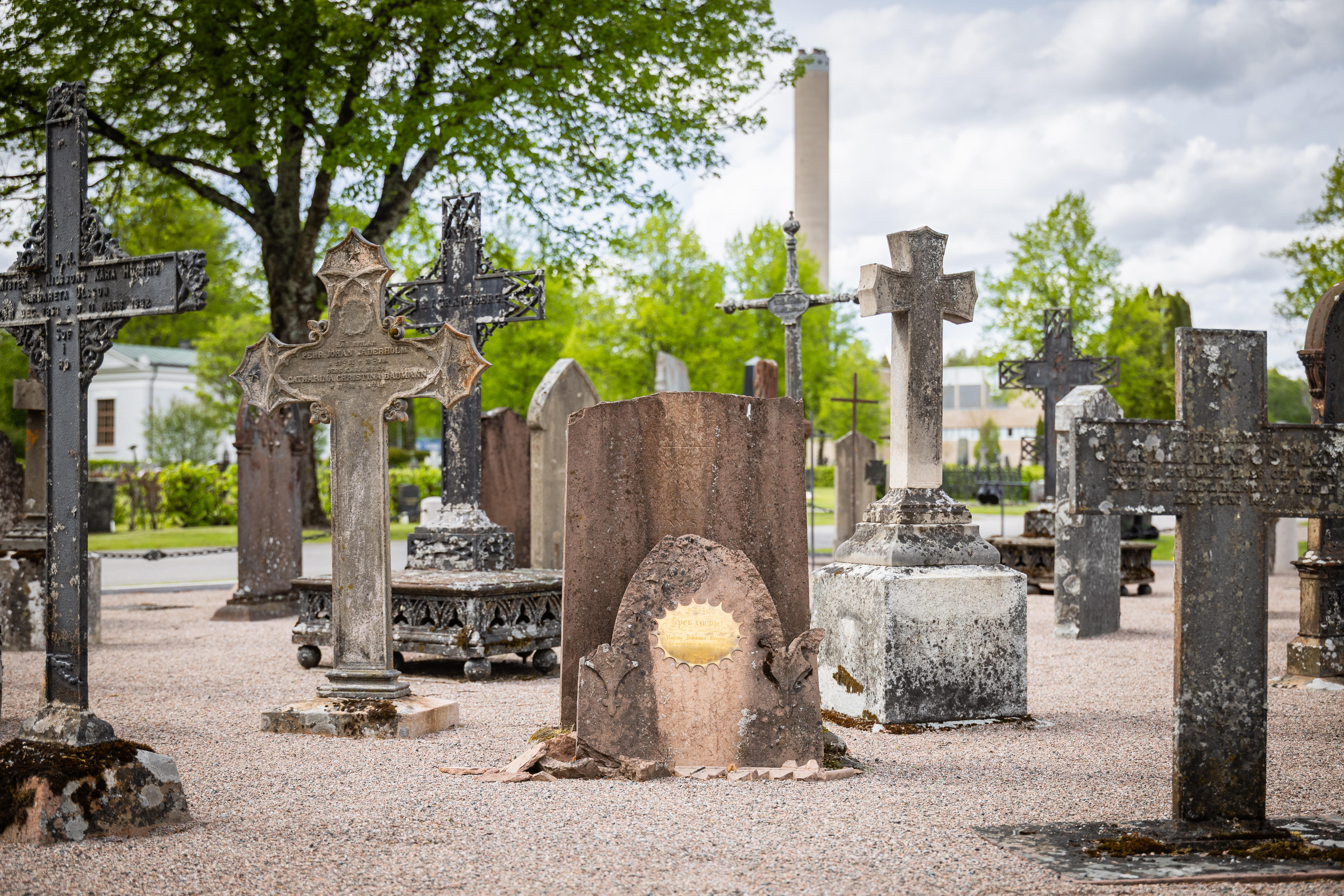 En samling med äldre gravstenar och ornament som samlats på kyrkogården för minne och dekoration