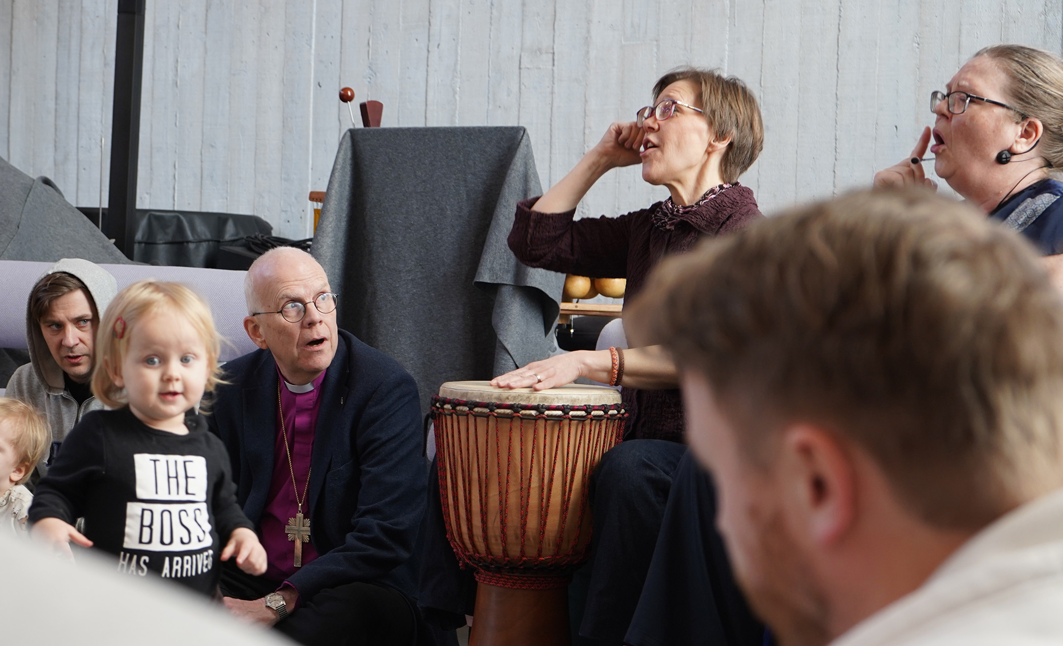 Ärkebiskop Martin Modéus deltar i sångstunden med små barn och deras föräldrar på S:t Pers förskola. Ledarna trummar och sjunger och ett barn går nyfiket mot kameran.