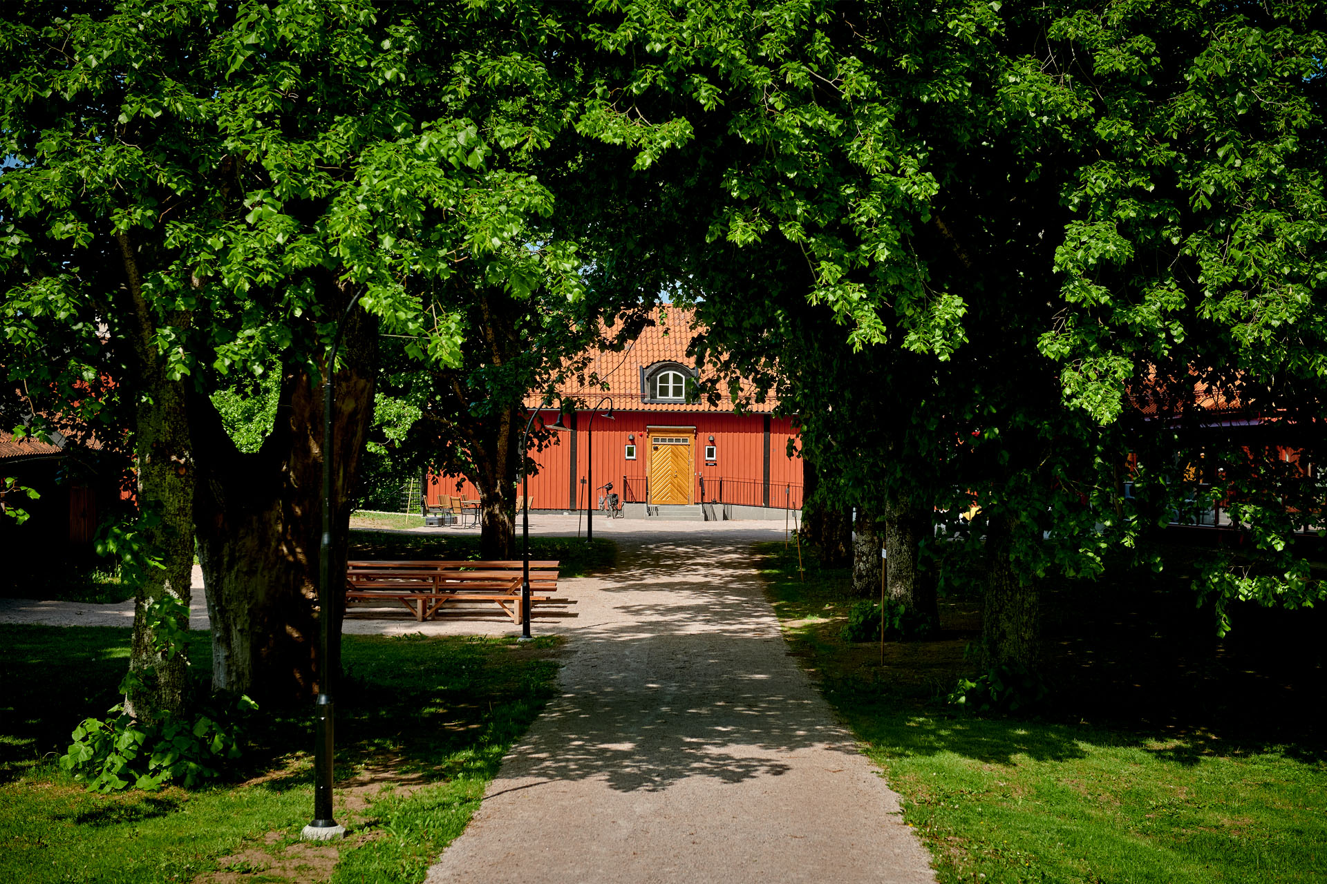 En grönskande allé med prästgården i mitten.