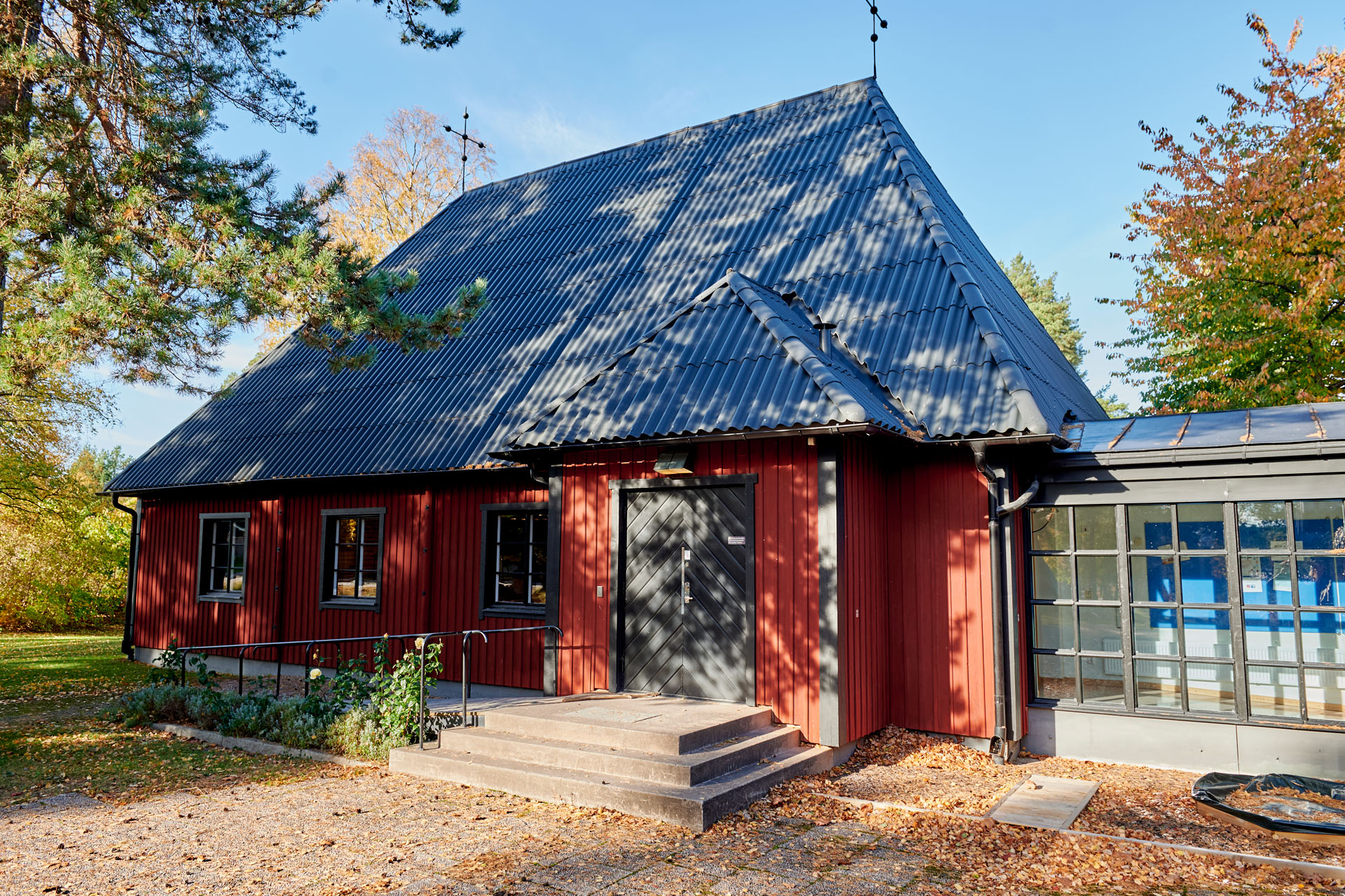 Ingången till Sunnersta kyrka. Solen som skiner på dörren silas genom tallgrenar.
