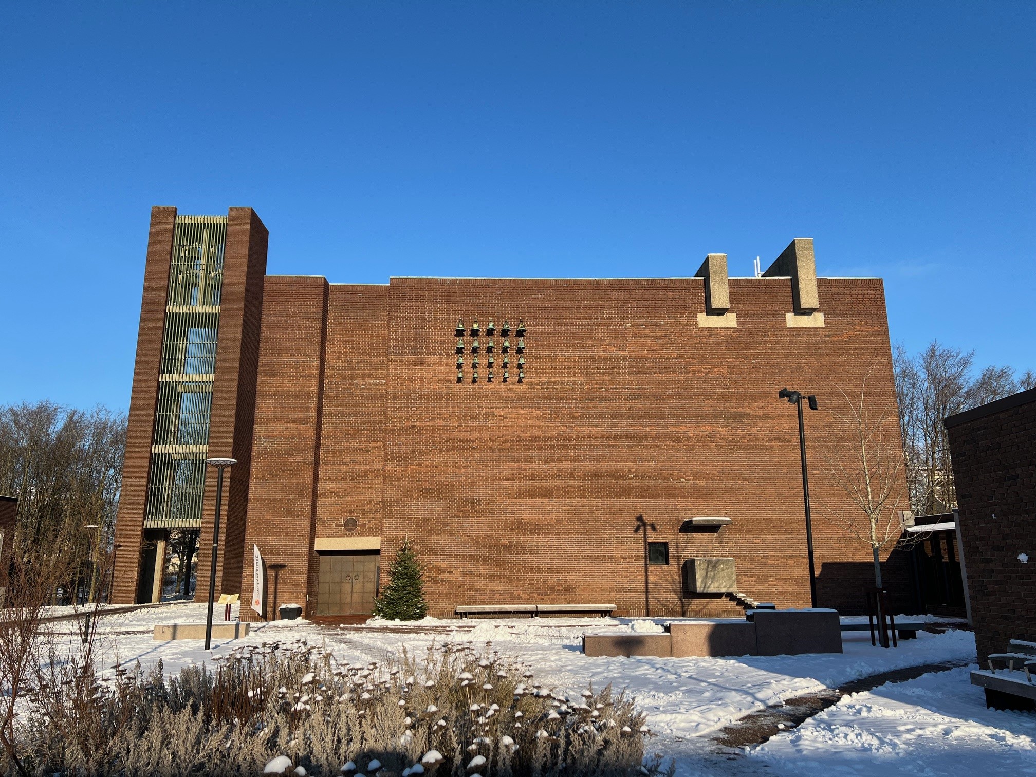 Helgeandskyrkan med snötäckt torg och blå himmel