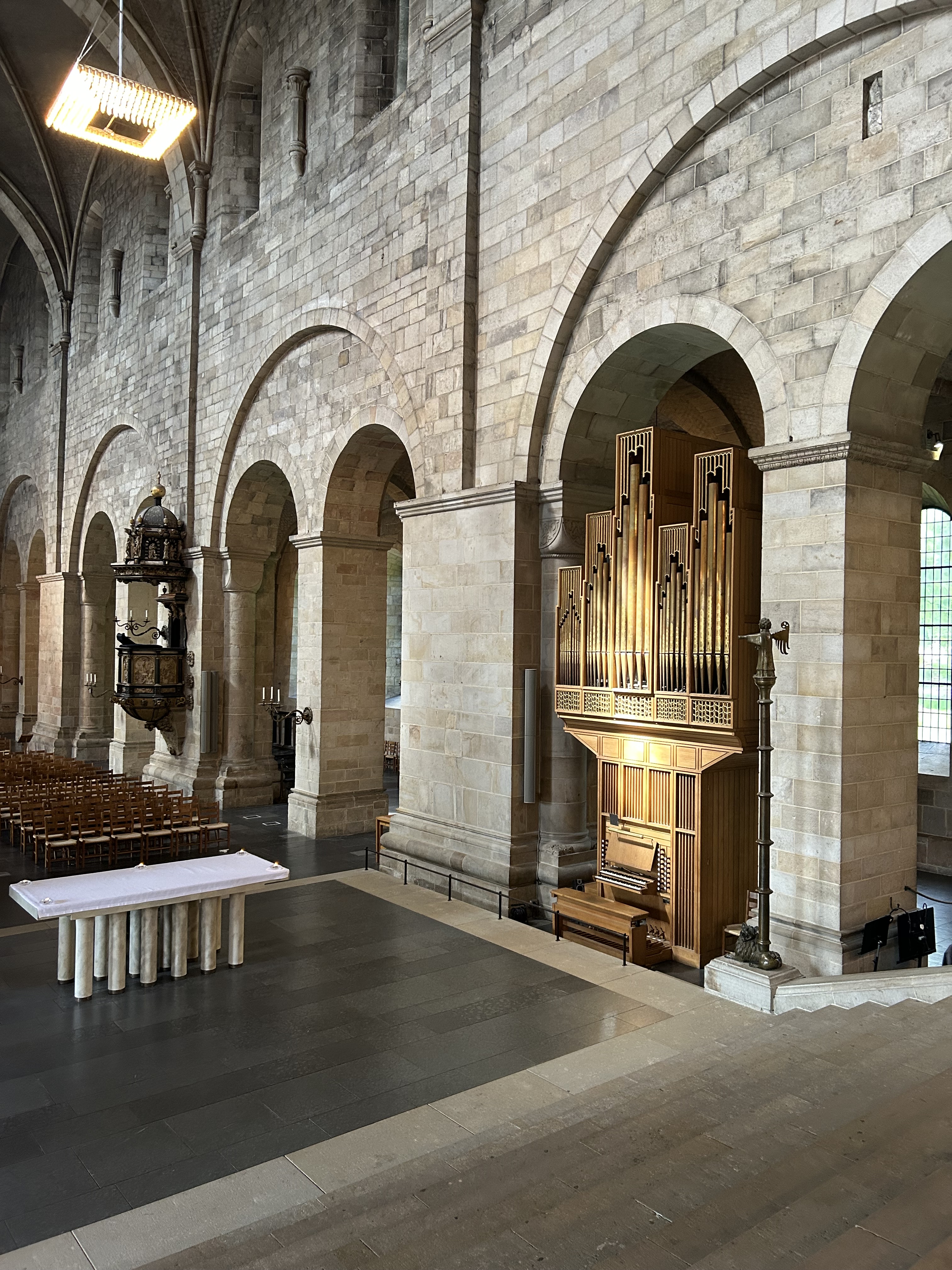 till vänster ses ett altare och till vänster en orgel som badar i solljus.