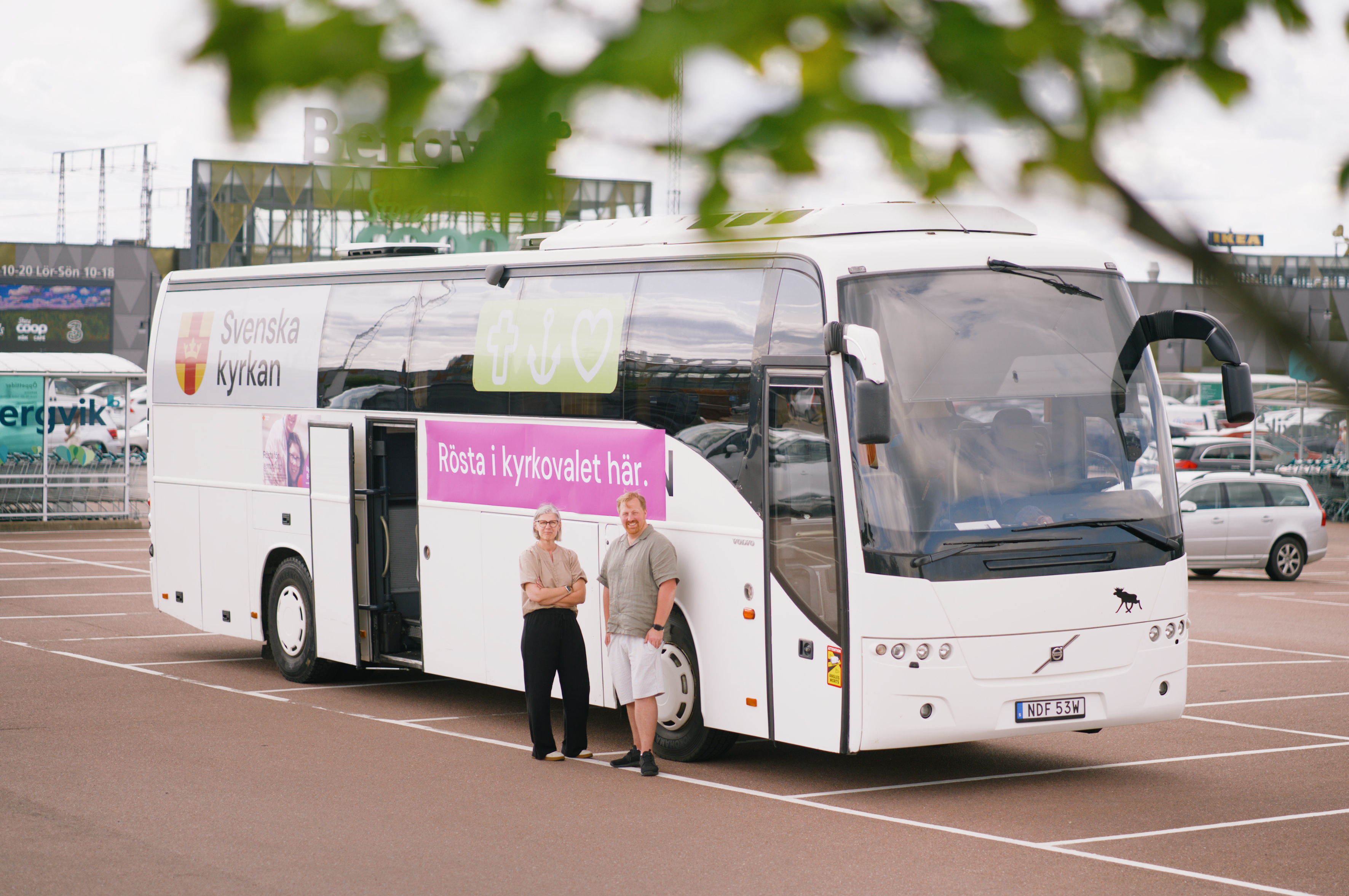 Två personer står vid Valbussen, som också är Ungdomsbussen.