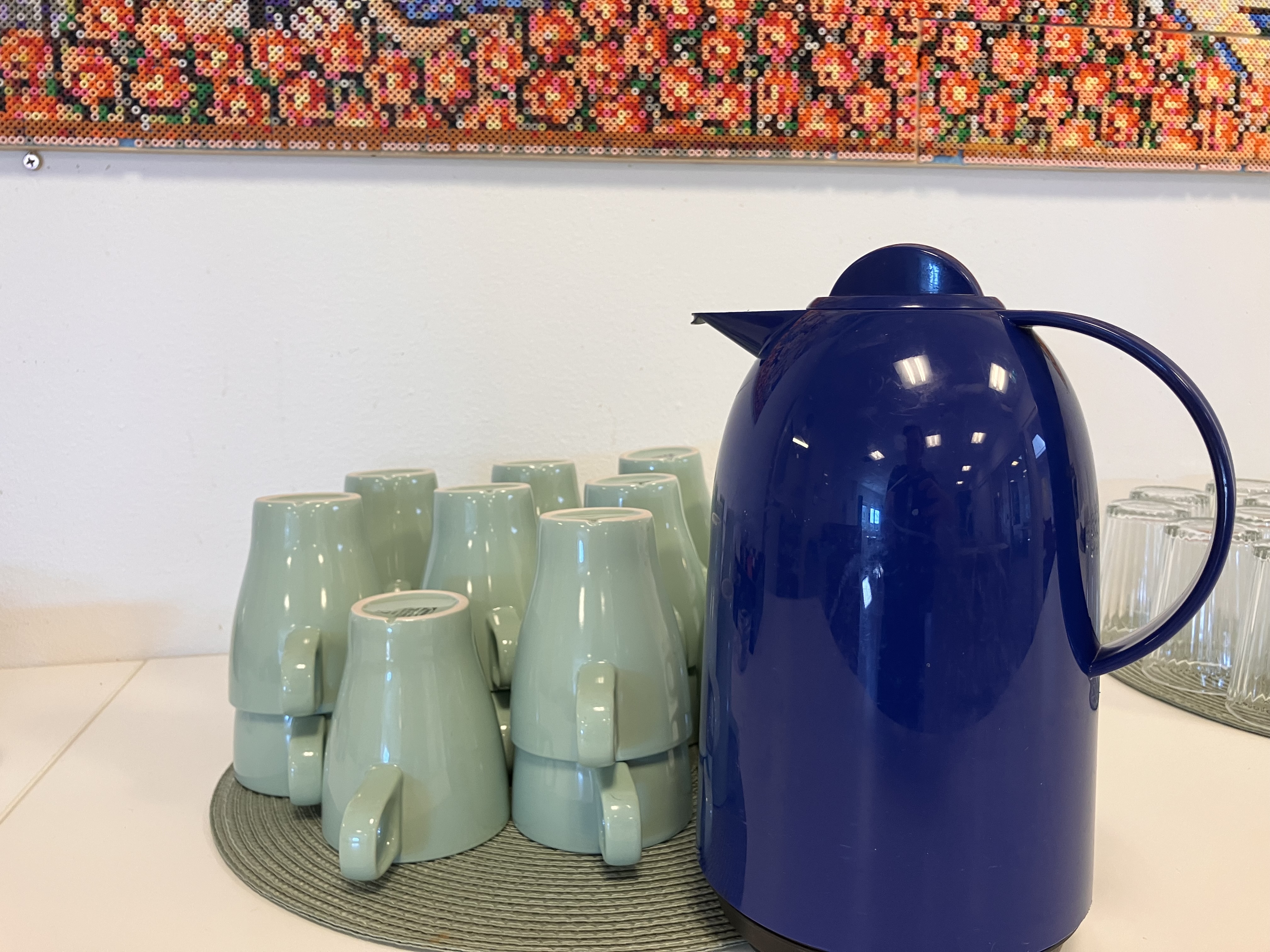 En blå kaffetermos och ljusgröna kaffemuggar