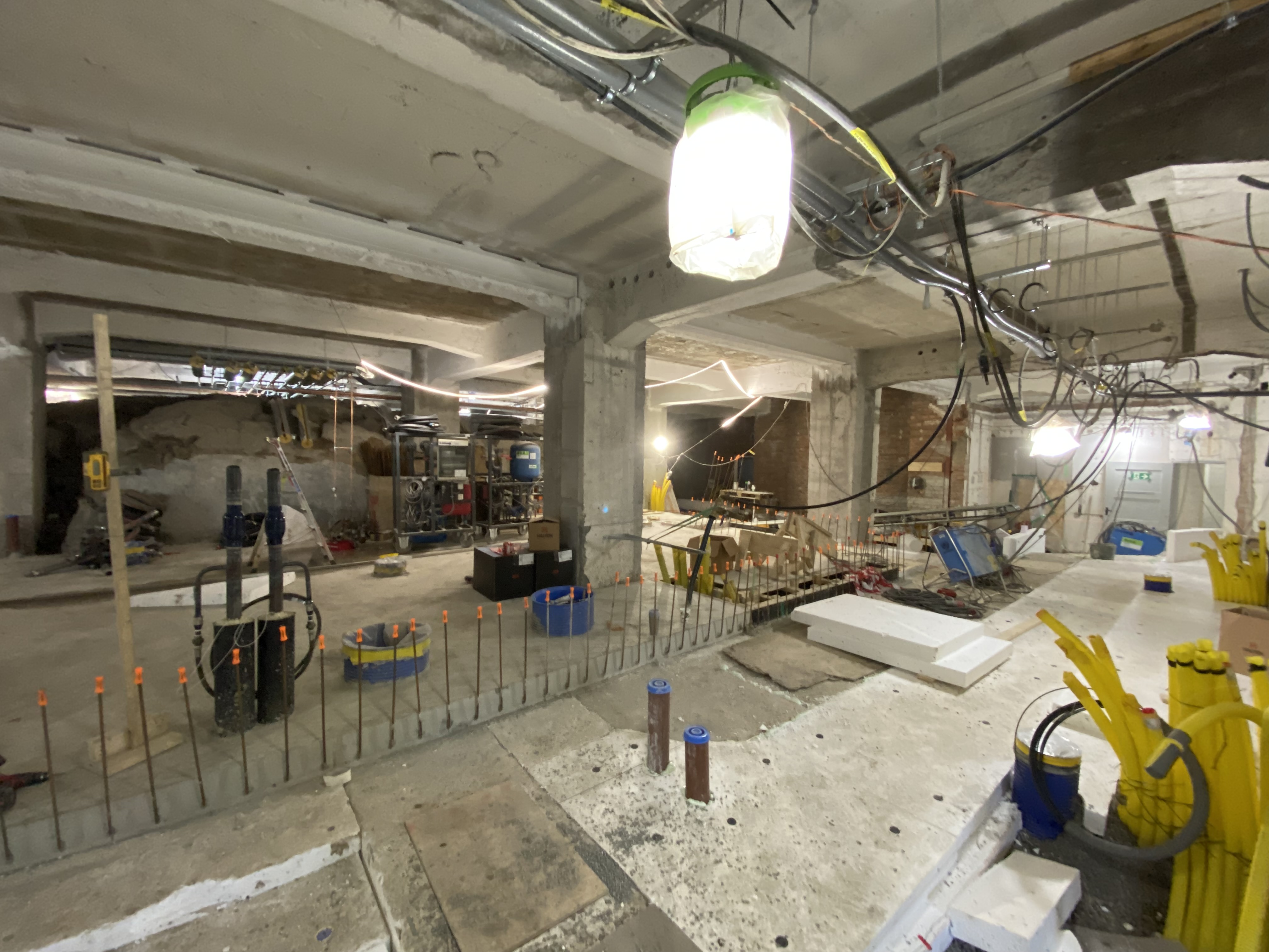 Utgrävning under kyrkan. Rör och kablar, delvis gjutet golv.