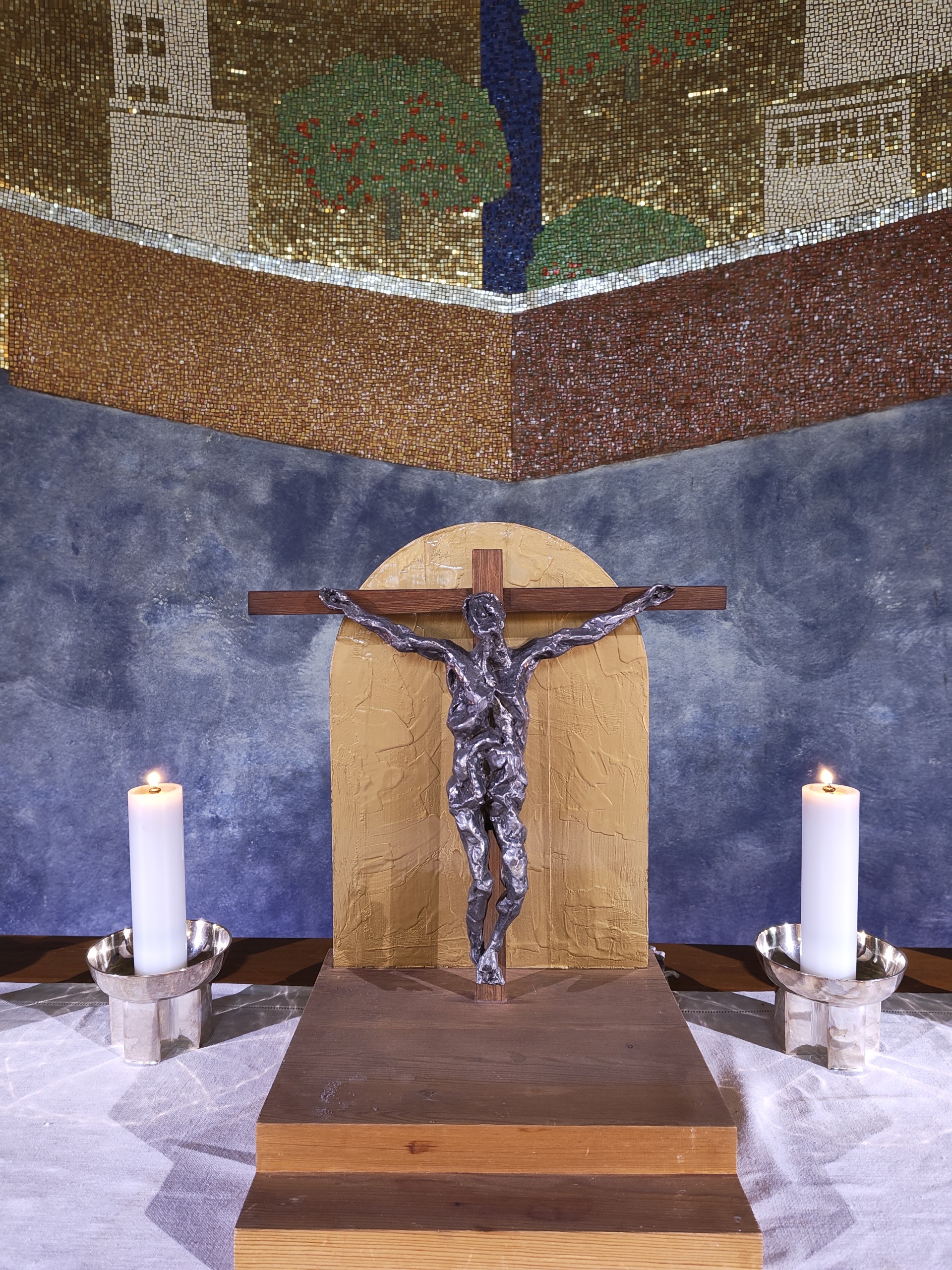altarkrucifix i kyrka två ljus på varsin sida