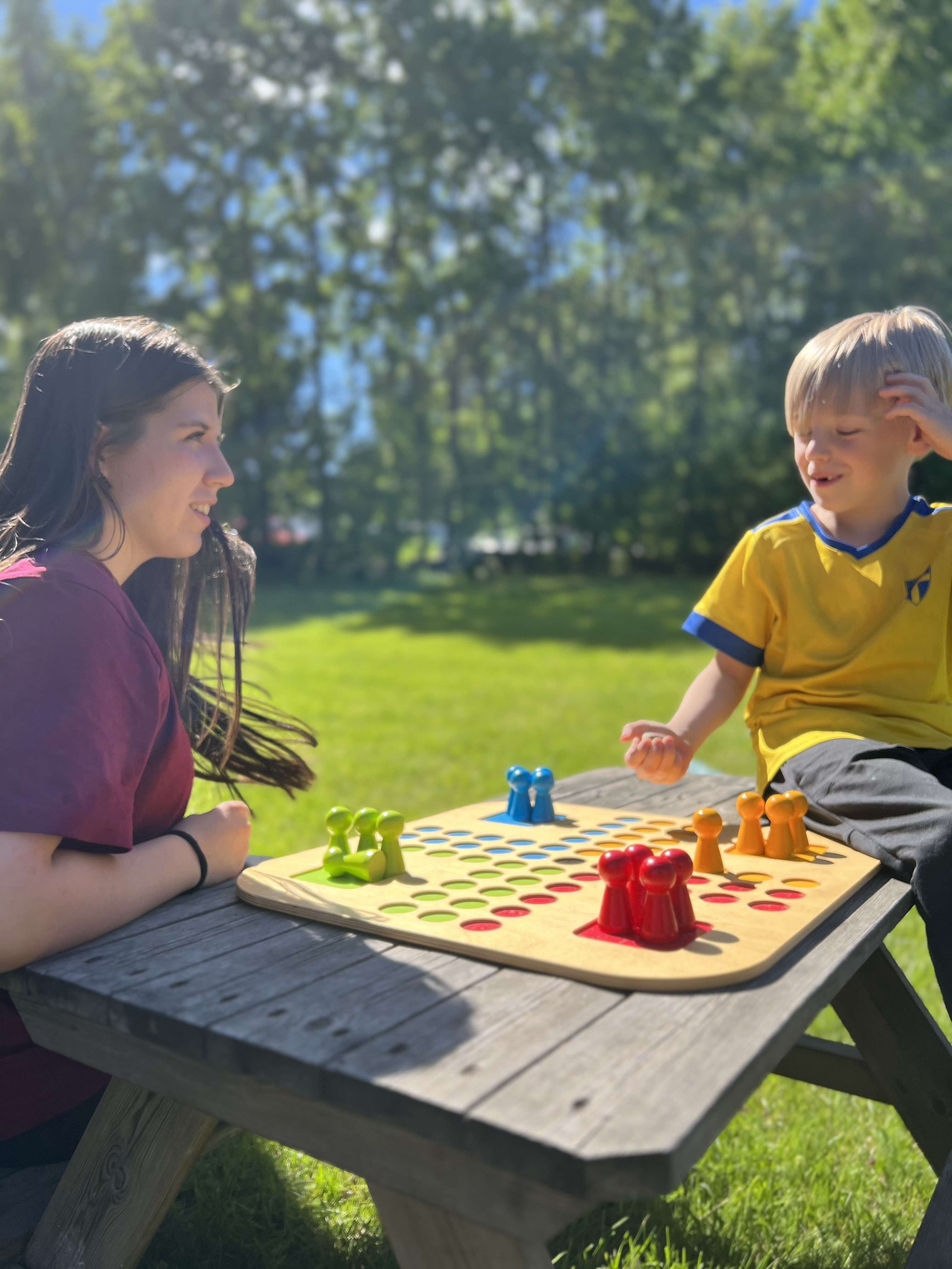 En ungdom från Sommarkyrkan spelar fia med knuff med ett barn