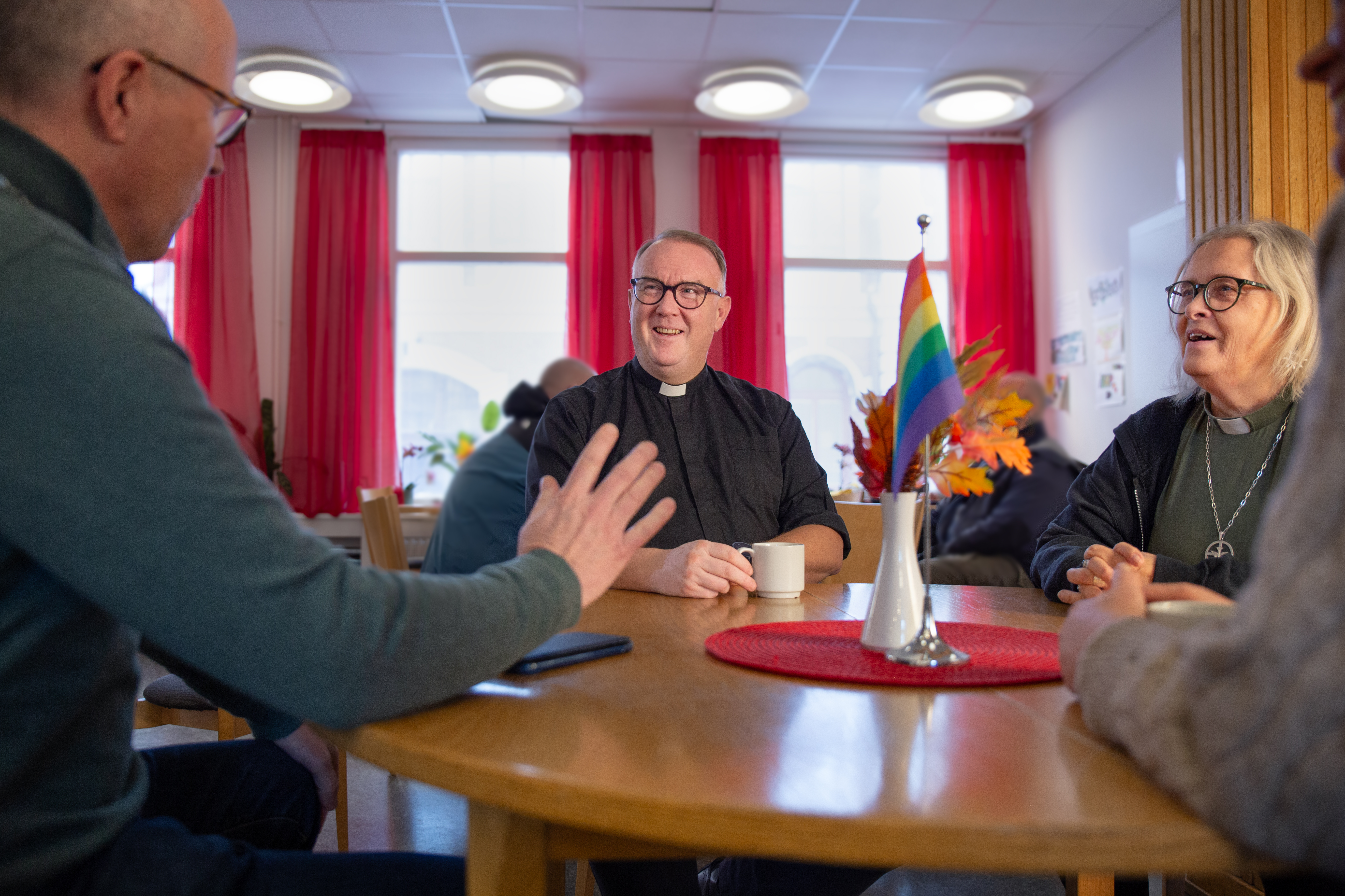 samtal på diakonins hus två män samtalar vid bord inomhus