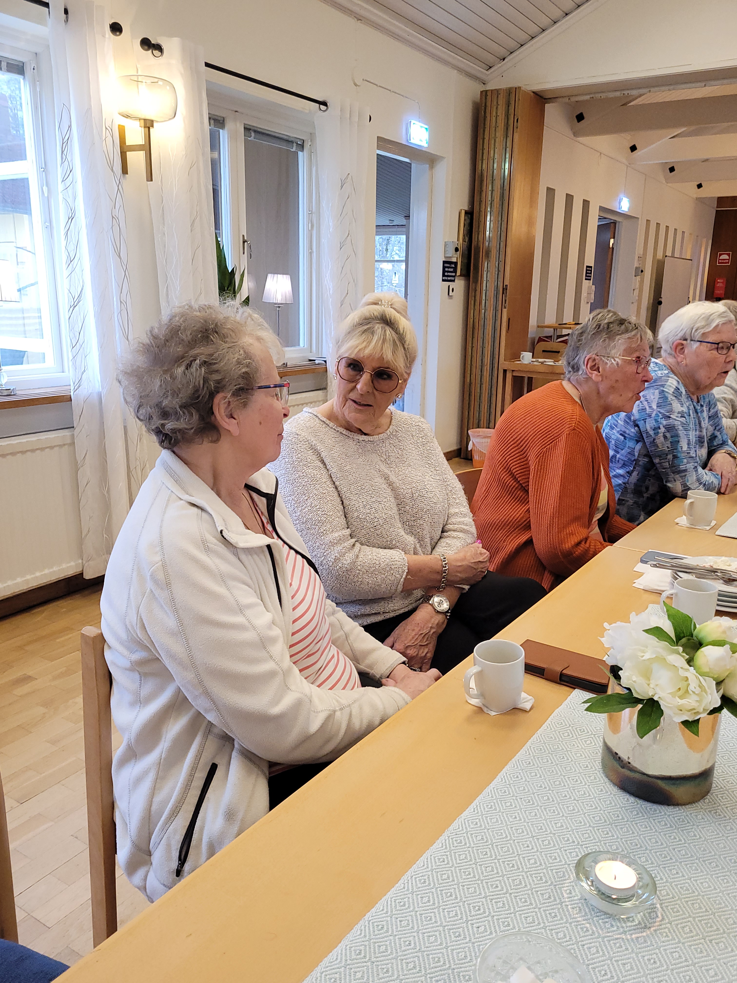 Två kvinnor sitter vid ett fikabord och pratar
