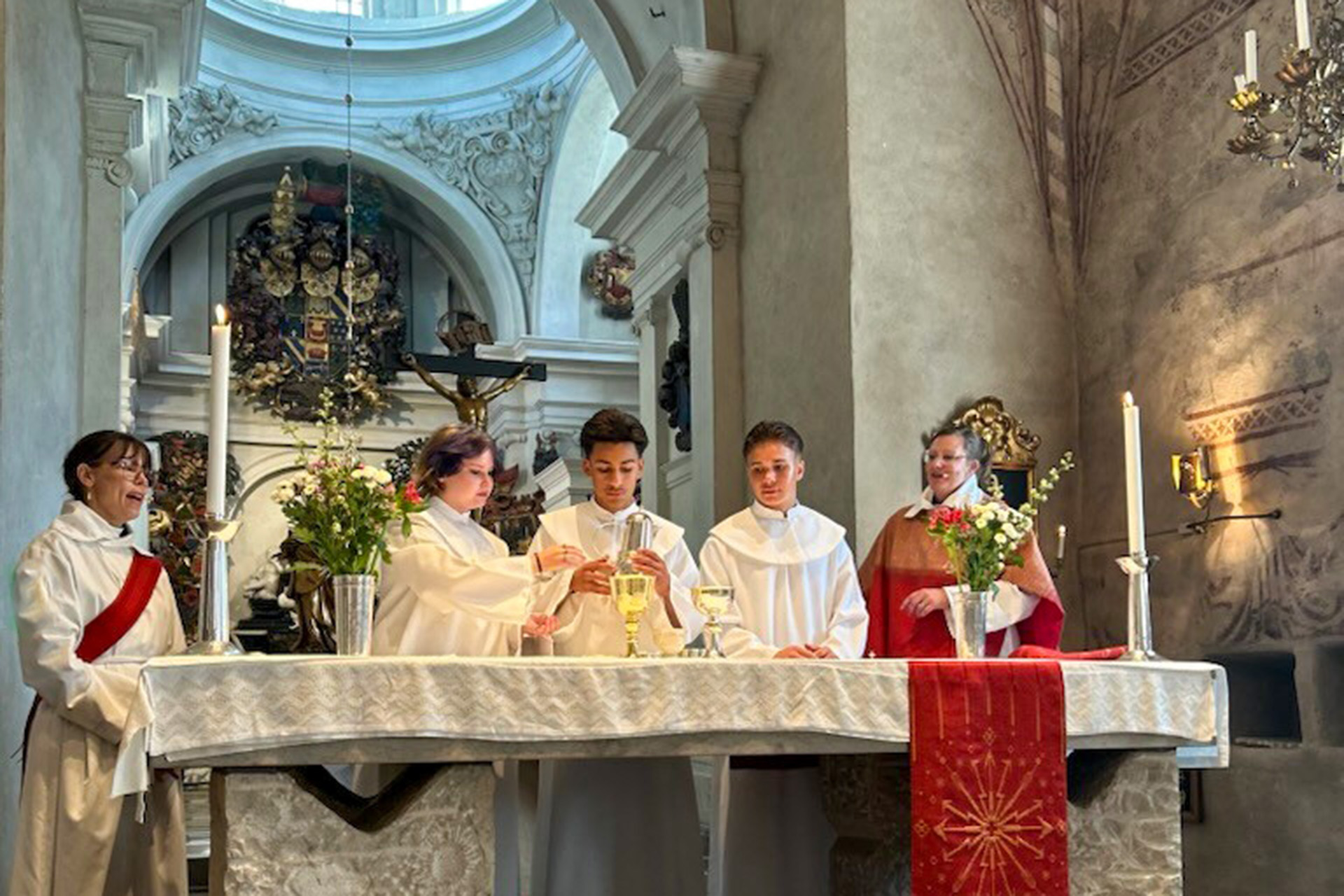 Konfirmander dukar till nattvard tillsammans med diakon och präst i Spånga kyrka