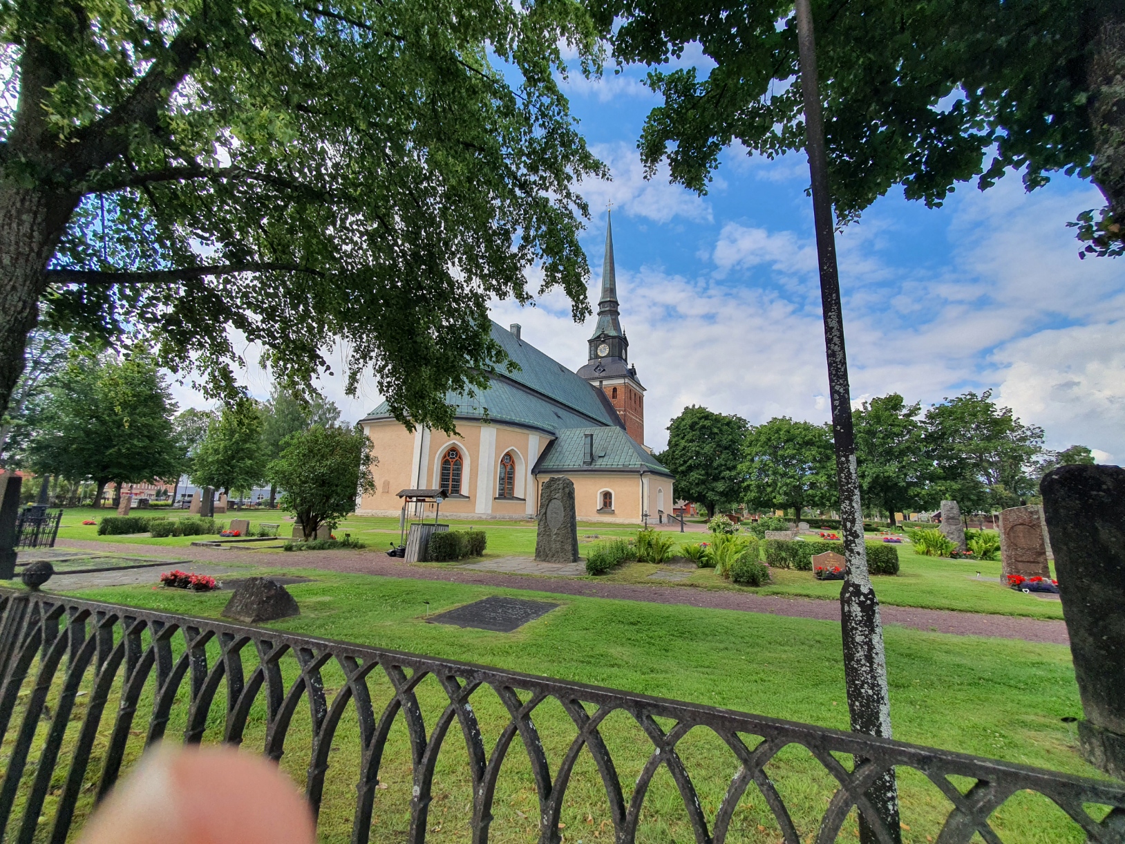sommarvy mora kyrka ljusgul kyrka grönt koppartak tegelrött torn 