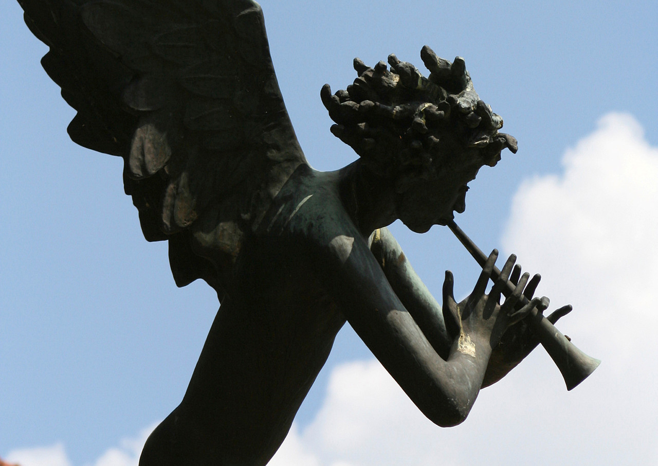 Skulptur av ängel som spelar trumpet.