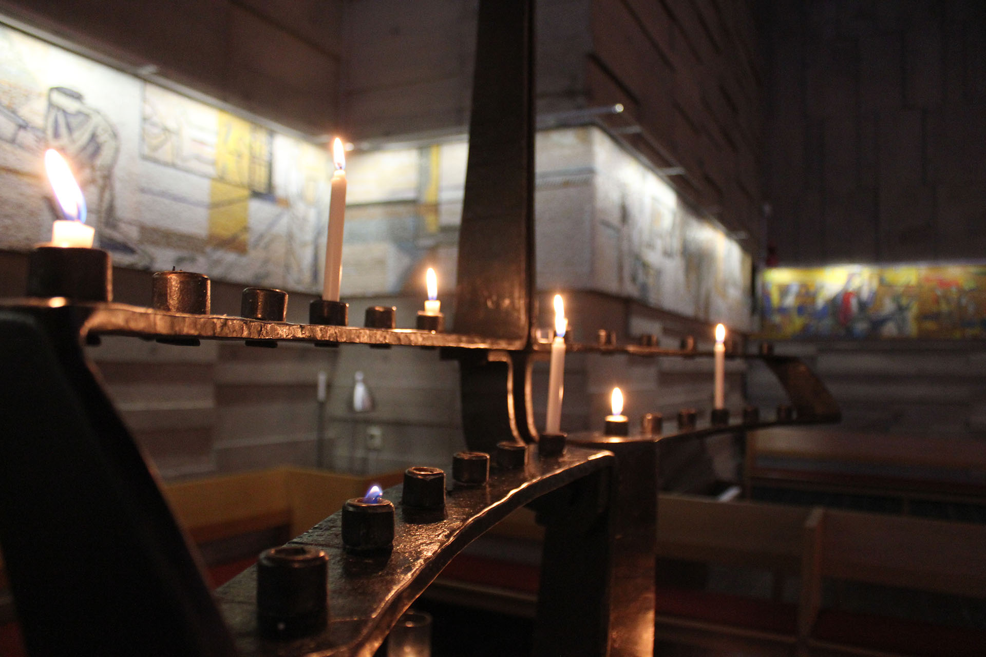 Den smidda ljusbäraren av Berth Johansson med tända ljus.